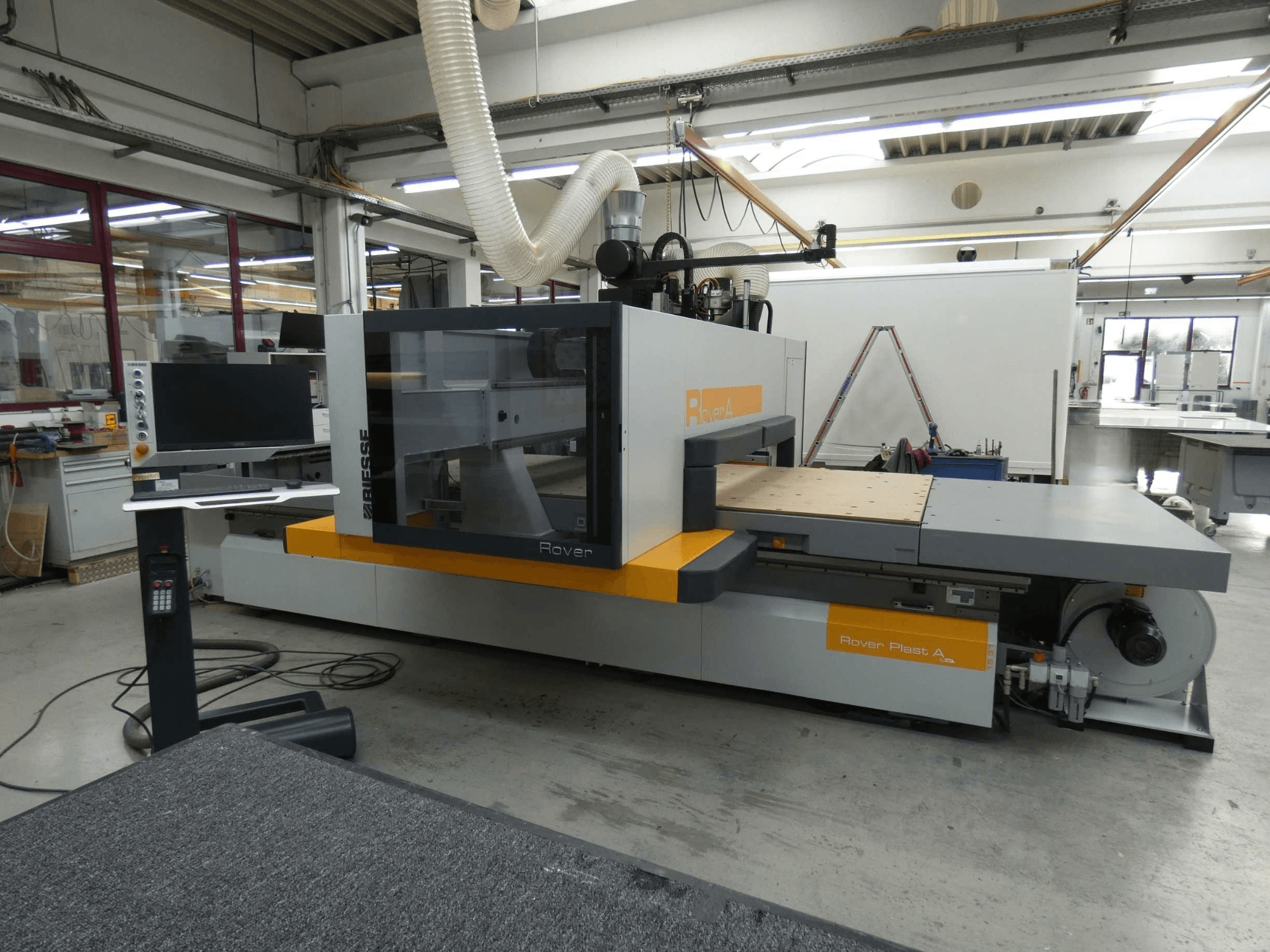 Vista frontal del centro de mecanizado de madera BIESSE ROVER PLAST A FT 1224 CNC, en la que se aprecian el monitor y el panel de control.