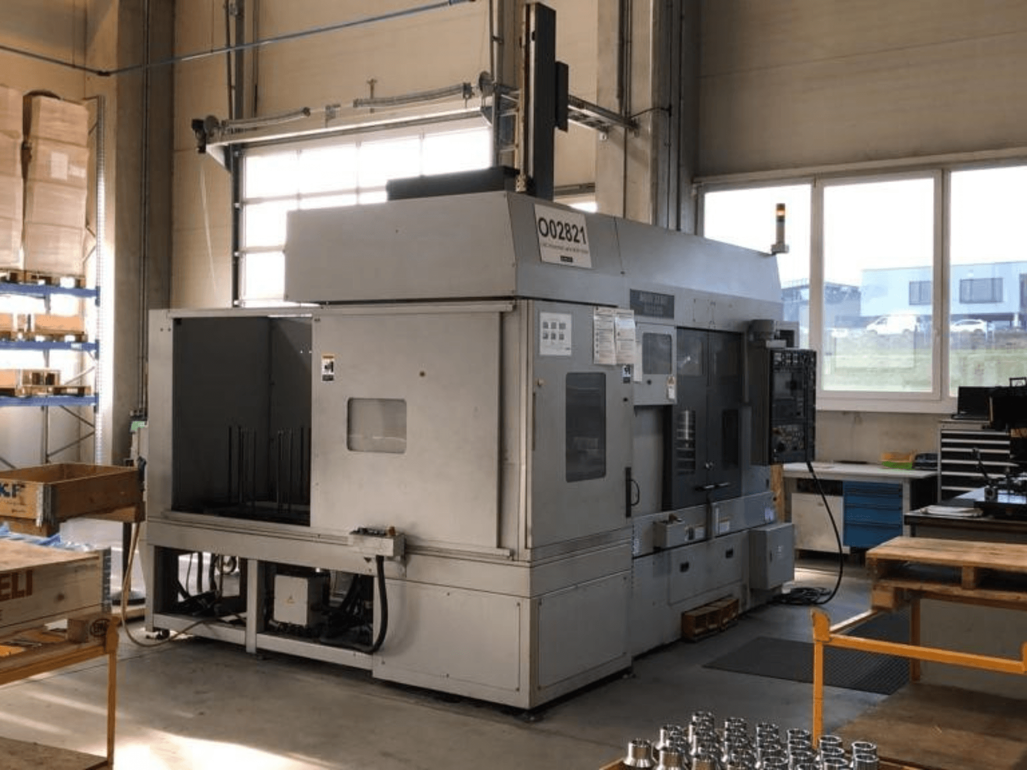 Máquina de torneado multihusillo MORI SEIKI RL2500 en un taller, mostrando la vista frontal y el área de producción con herramientas.