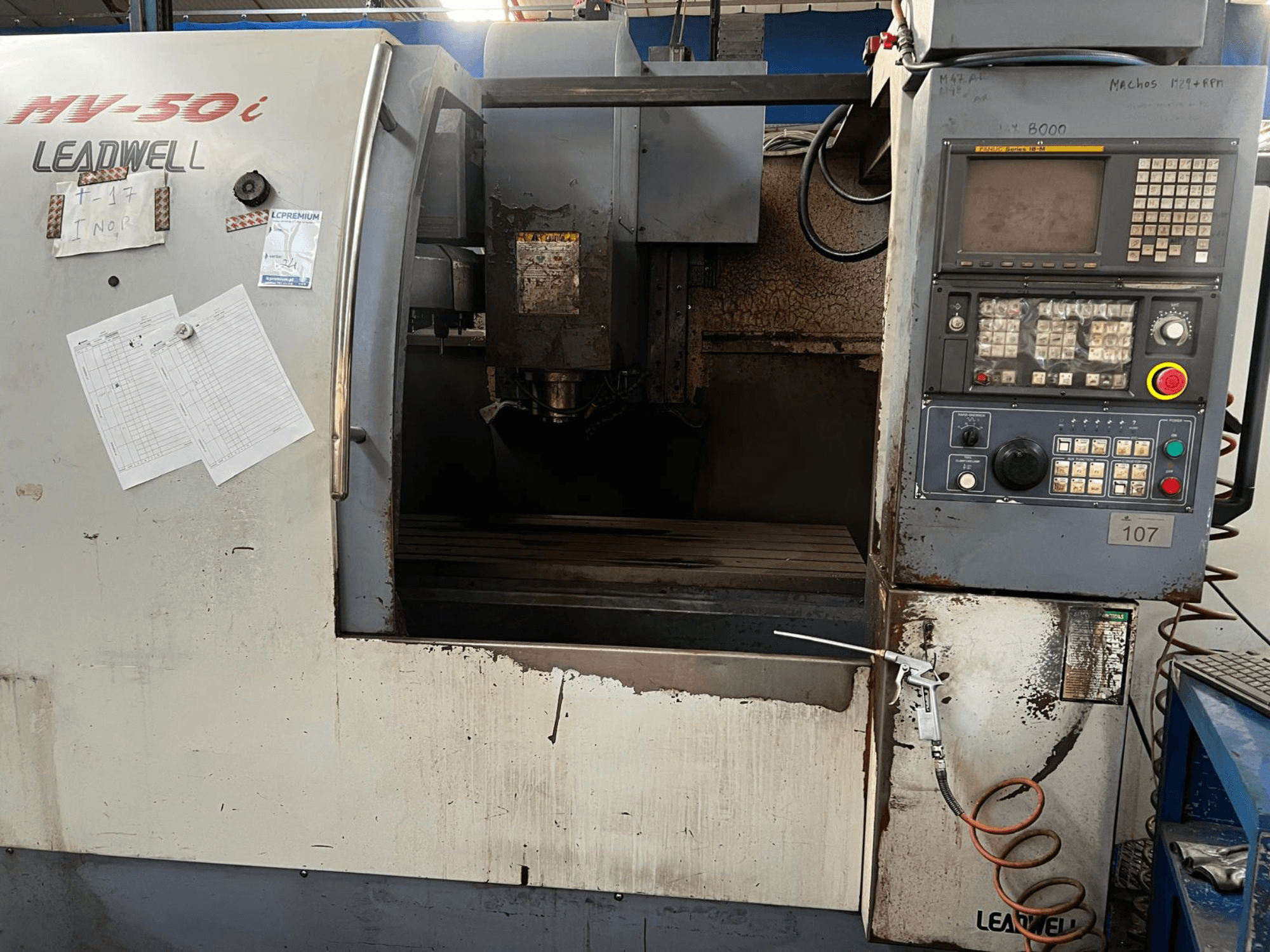 Centro de mecanizado vertical Leadwell MV-50i, vista frontal, en la que se aprecian el panel de control, la zona del husillo y la mesa de trabajo con signos de desgaste.