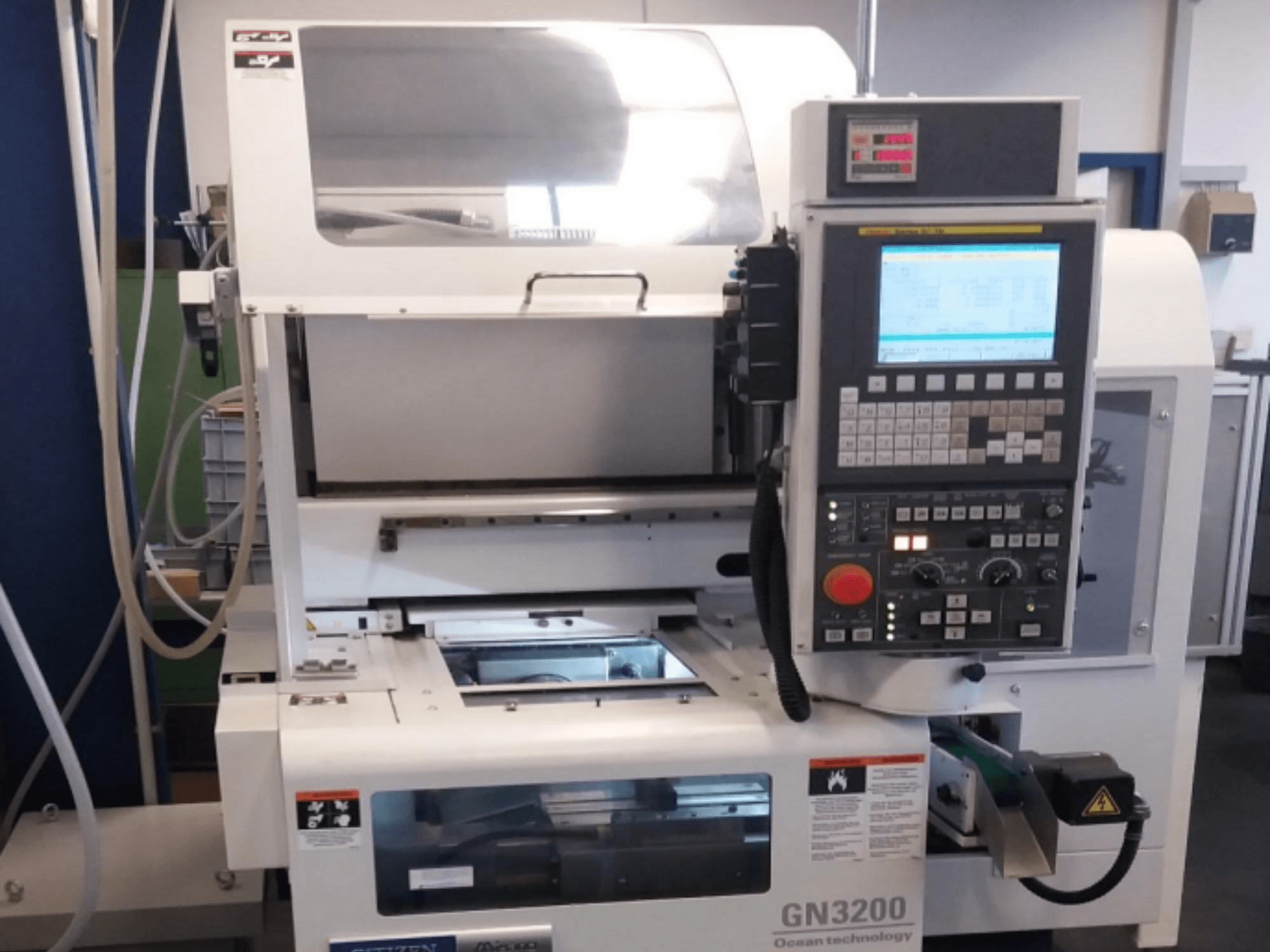 Máquina de torneado horizontal Citizen MIYANO GN 3200, vista frontal, mostrando el panel de control y los componentes operativos.