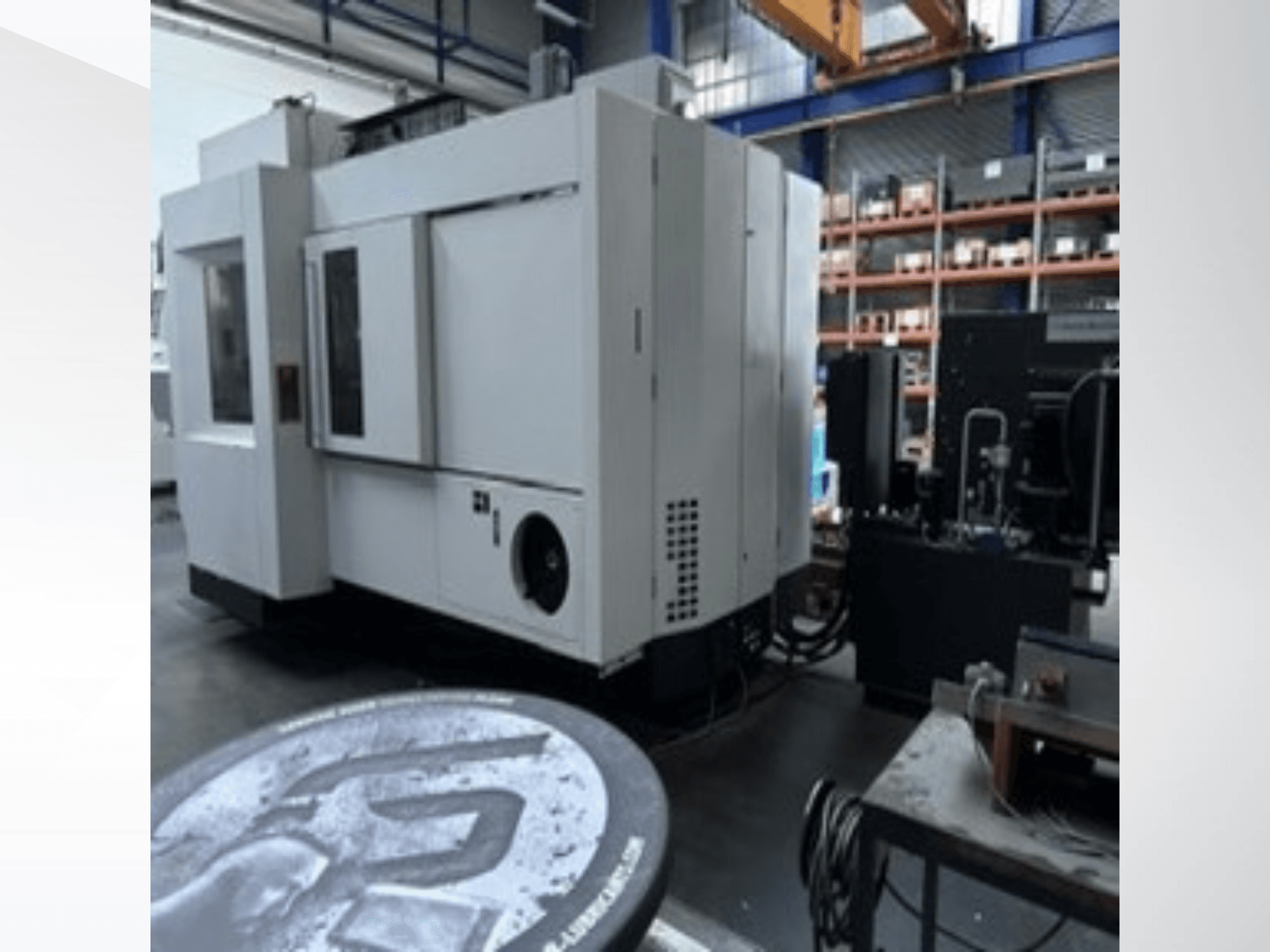 Centro de mecanizado universal MIKRON HPM 1350 U de color blanco en un taller; vista lateral en la que se aprecia el gran panel de control y el entorno industrial.