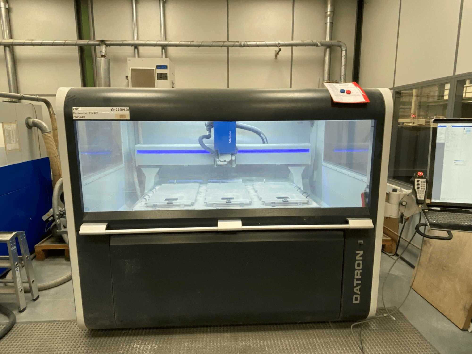 Centro de mecanizado vertical Datron MLCube B, vista frontal, mostrando el interior de la máquina y el panel de control.