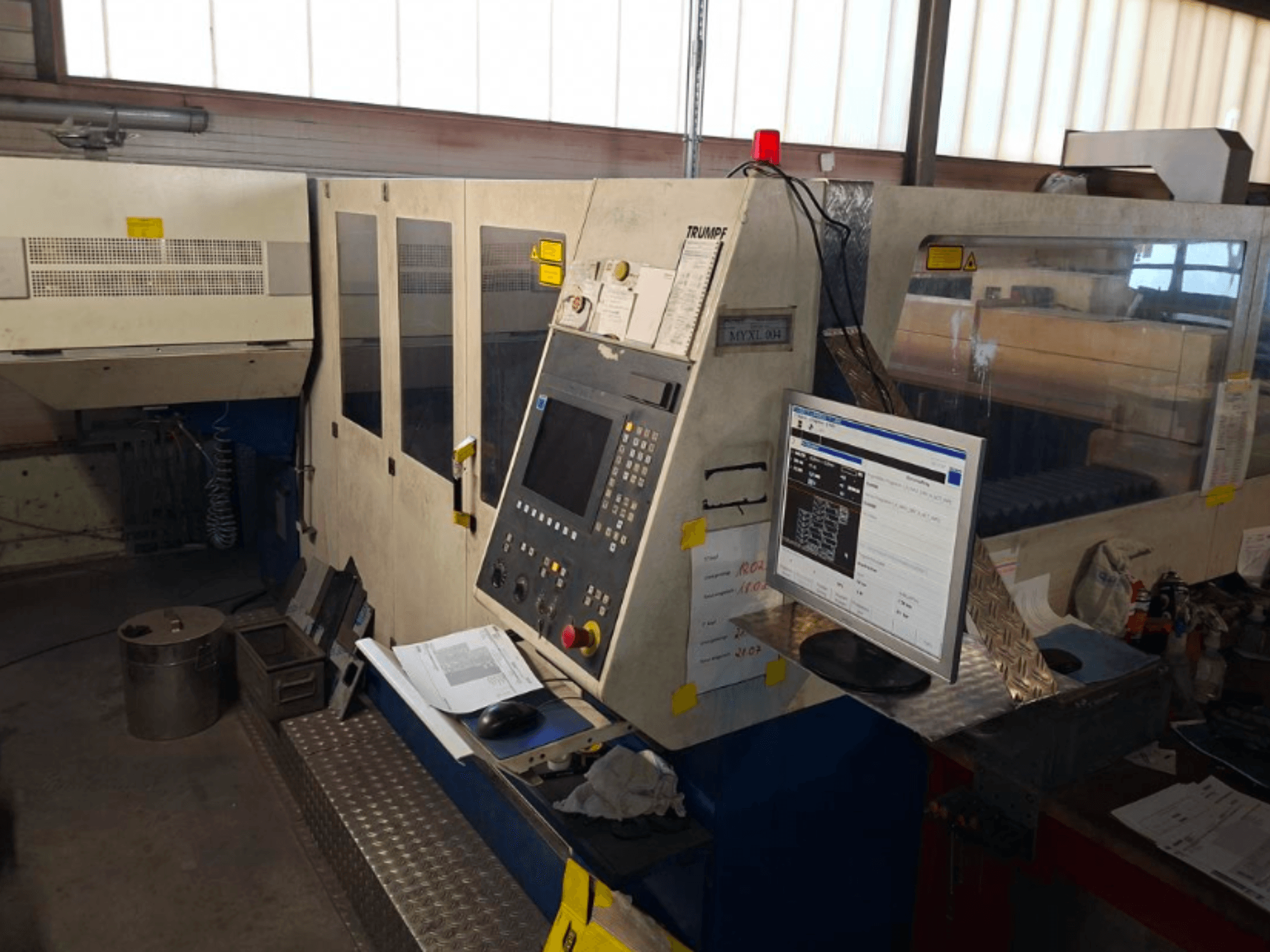 Máquina de corte por láser de CO2 TRUMPF Trumatic L 4030, vista frontal mostrando el panel de control y el monitor, con detalles del espacio de trabajo visibles.