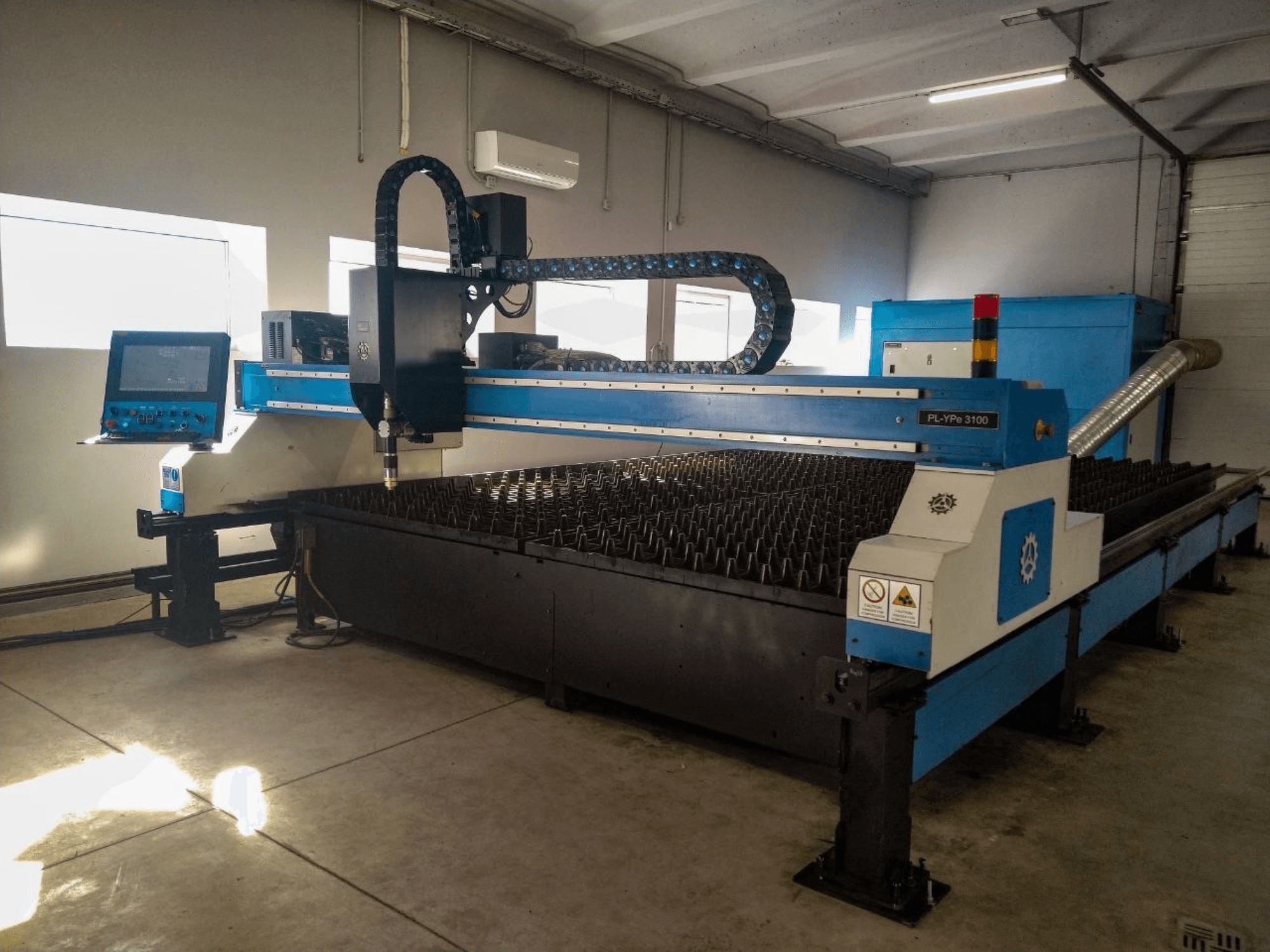Máquina de corte por plasma INANMAK MEKOR PL-YPe 3100, vista frontal, con panel de control y mesa de corte con picos metálicos elevados.