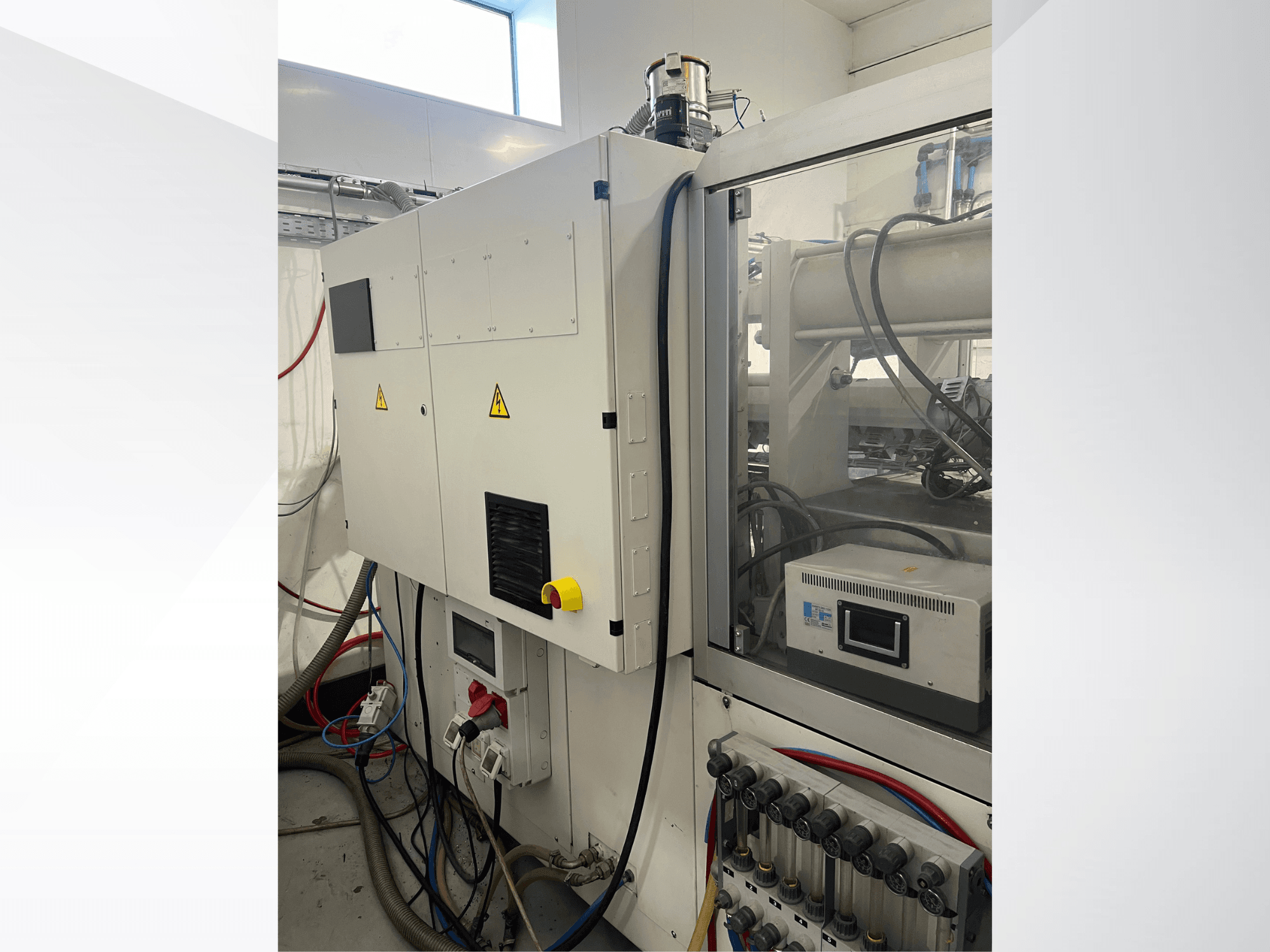 Máquina de moldeo por inyección hidráulica Krauss Maffei 125-520 C1; vista lateral en la que se aprecian el panel de control y las conexiones hidráulicas.