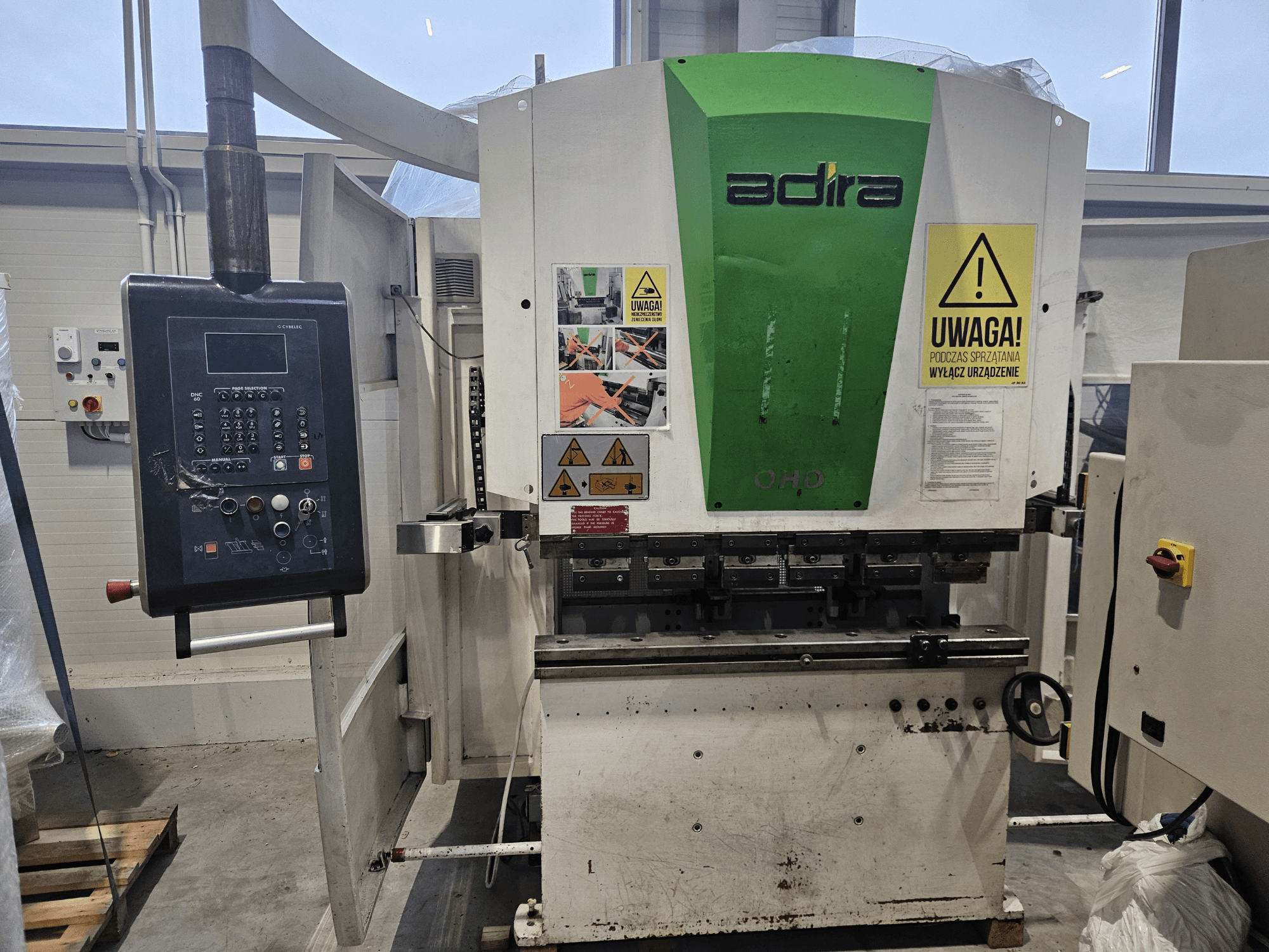 Máquina Adira OHD vista de frente, con panel de control, advertencias de seguridad y botones de funcionamiento.