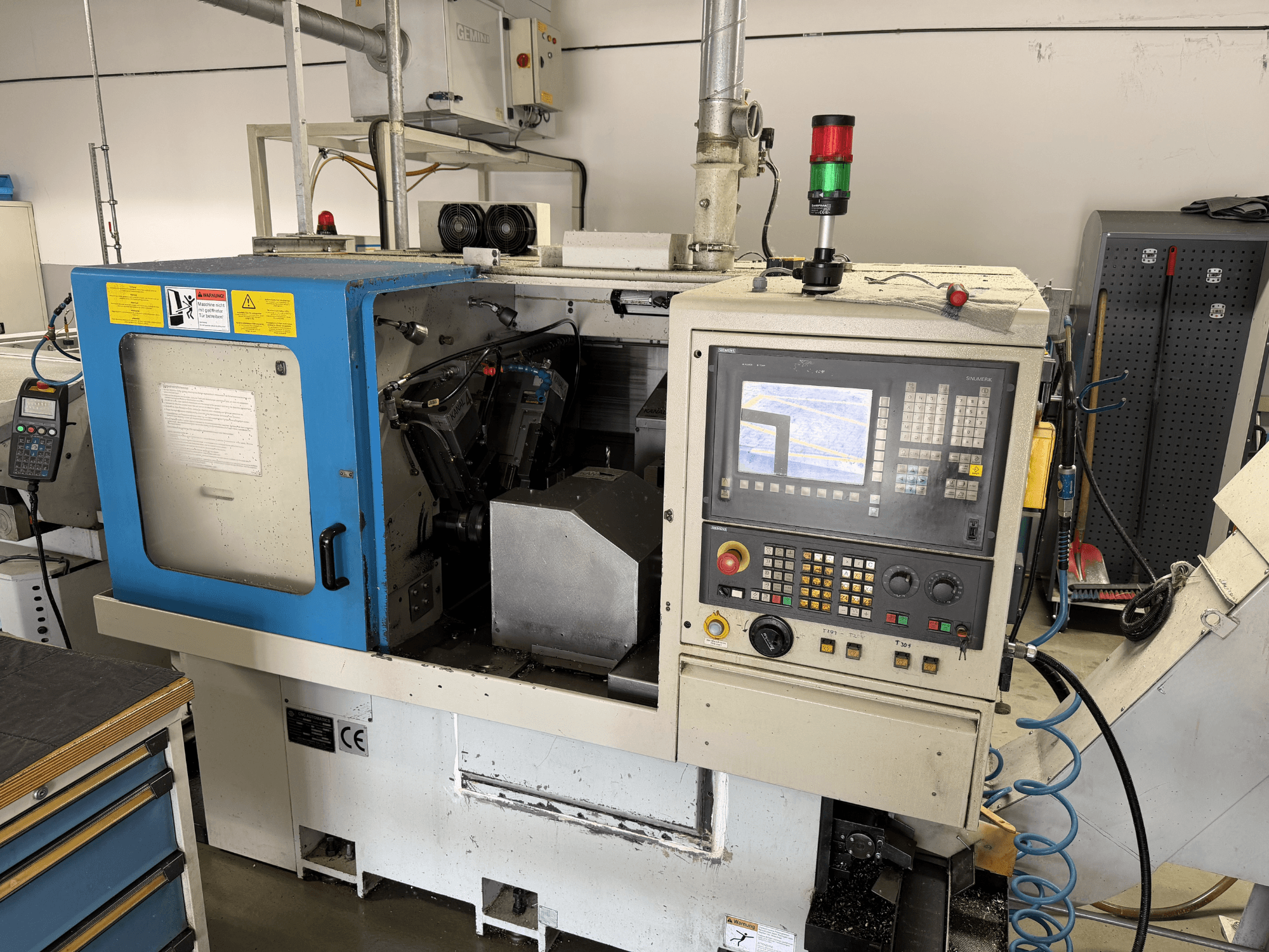 Torno horizontal LICO LNT 65 S en vista lateral, en la que se aprecian el panel de control, la zona de trabajo y los dispositivos de seguridad.