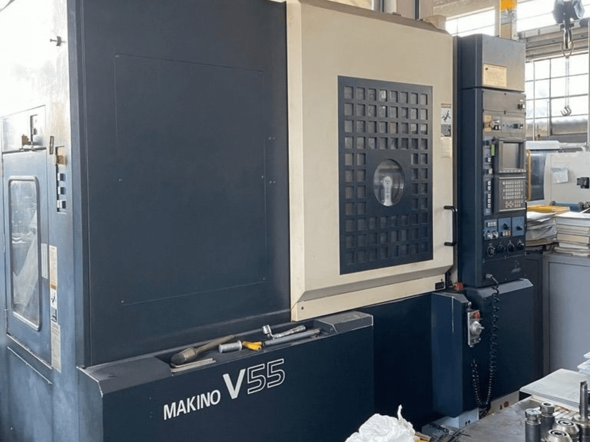 Centro de mecanizado vertical Makino V55-A15, vista frontal en la que se aprecian el panel de control, su estructura robusta y la configuración del espacio de trabajo.