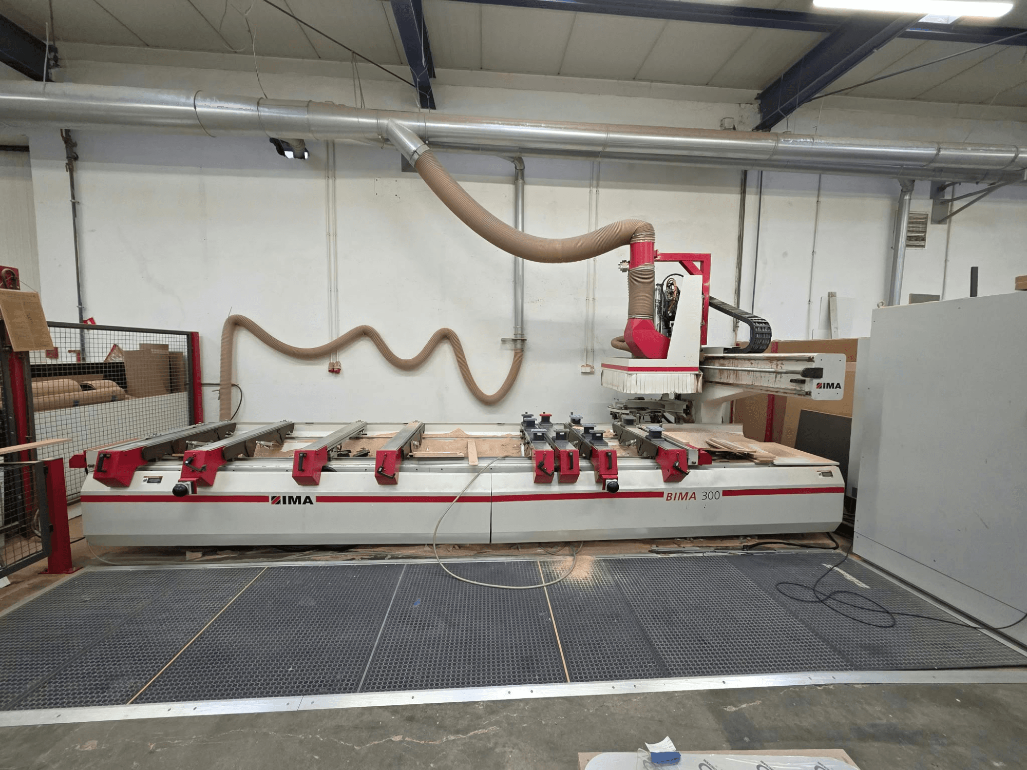 Centro de mecanizado de madera CNC IMA BIMA 300, vista frontal, equipado con una herramienta multieje y un sistema de extracción de polvo.