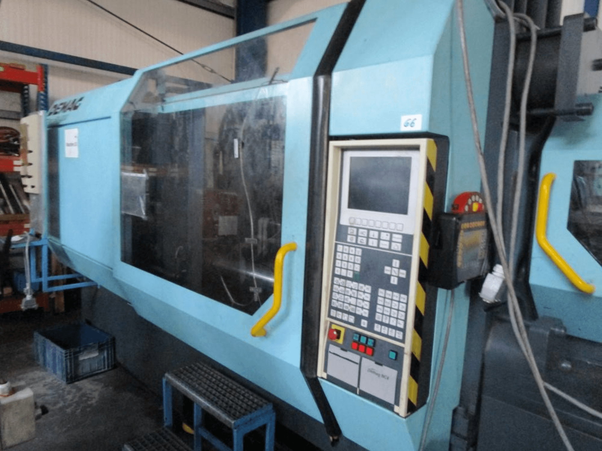 Máquina de moldeo por inyección hidráulica Demag Erdotech 500-3300, vista frontal, con panel de control y caja de seguridad transparente.