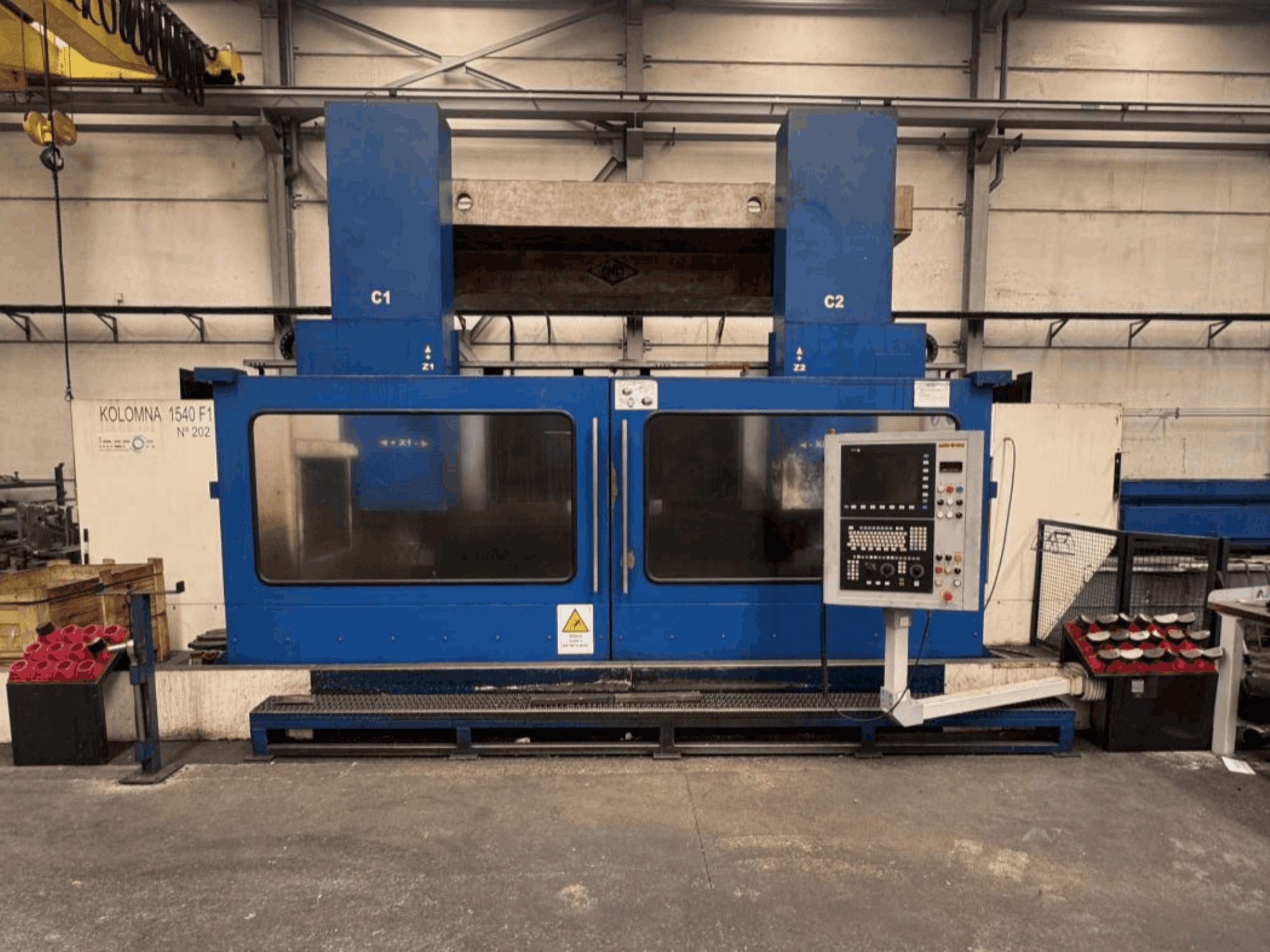 Torno vertical KOLOMNA 1540 F1 de color azul con panel de control, visto desde delante, en el que se aprecia su amplia zona de trabajo.