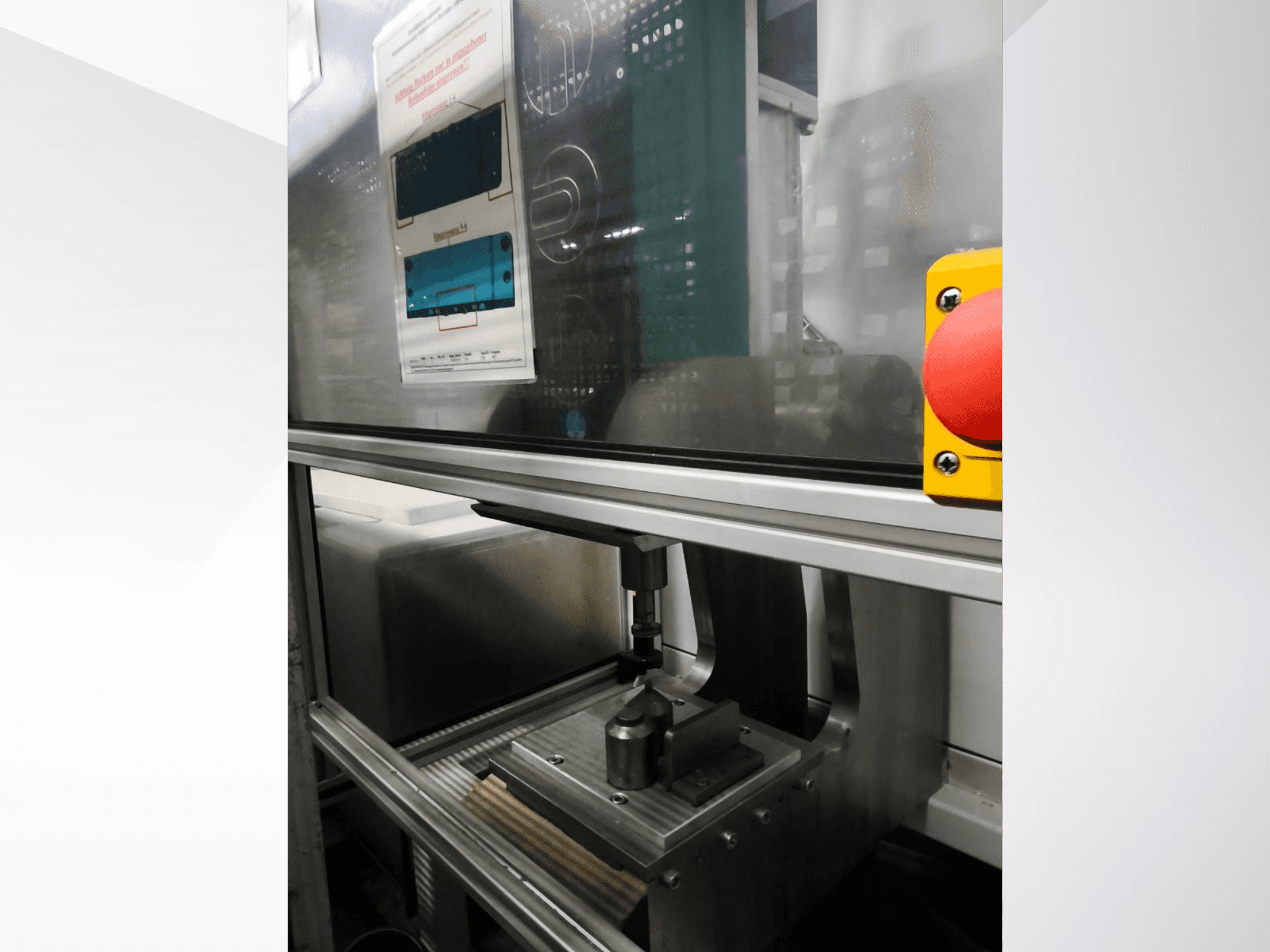 Vista frontal de la máquina herramienta Buchsenpresse de EMS Automation, que muestra el mecanismo de prensado y el botón de seguridad.