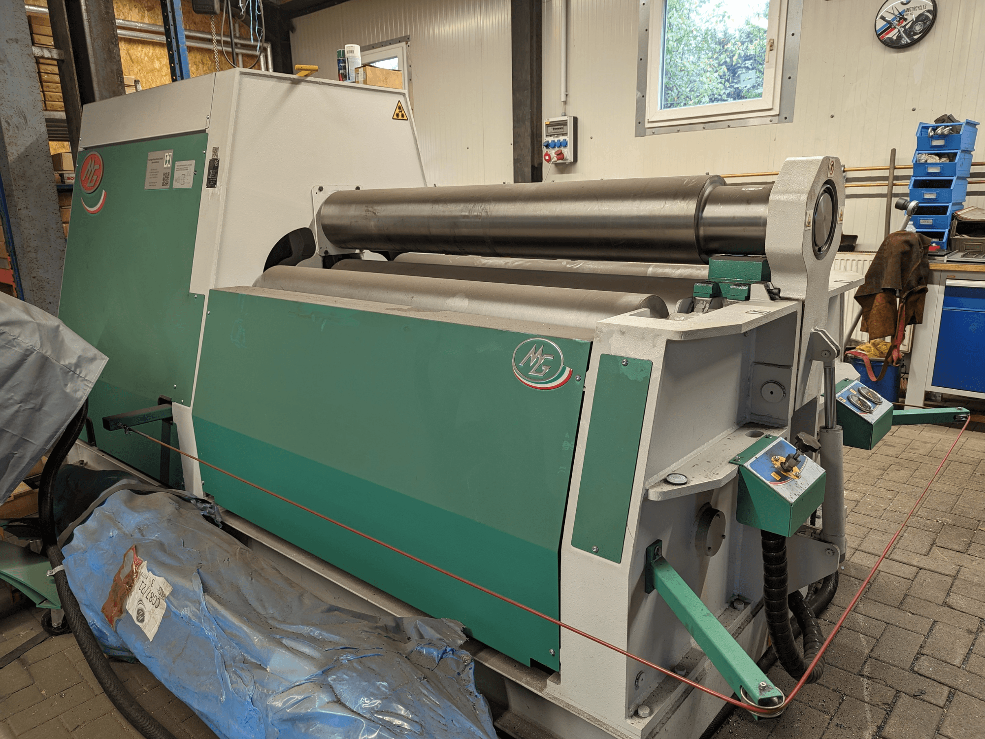 Máquina curvadora de rollos MG Modelo MG4R1520C en verde y gris, vista lateral mostrando tres rollos de metal y paneles de control.