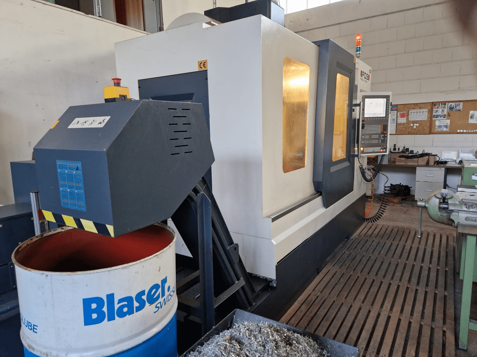 Vista frontal del centro de mecanizado vertical POSmill C 1050, con el sistema de refrigeración sobre el tambor Blaser y el panel de control visible.