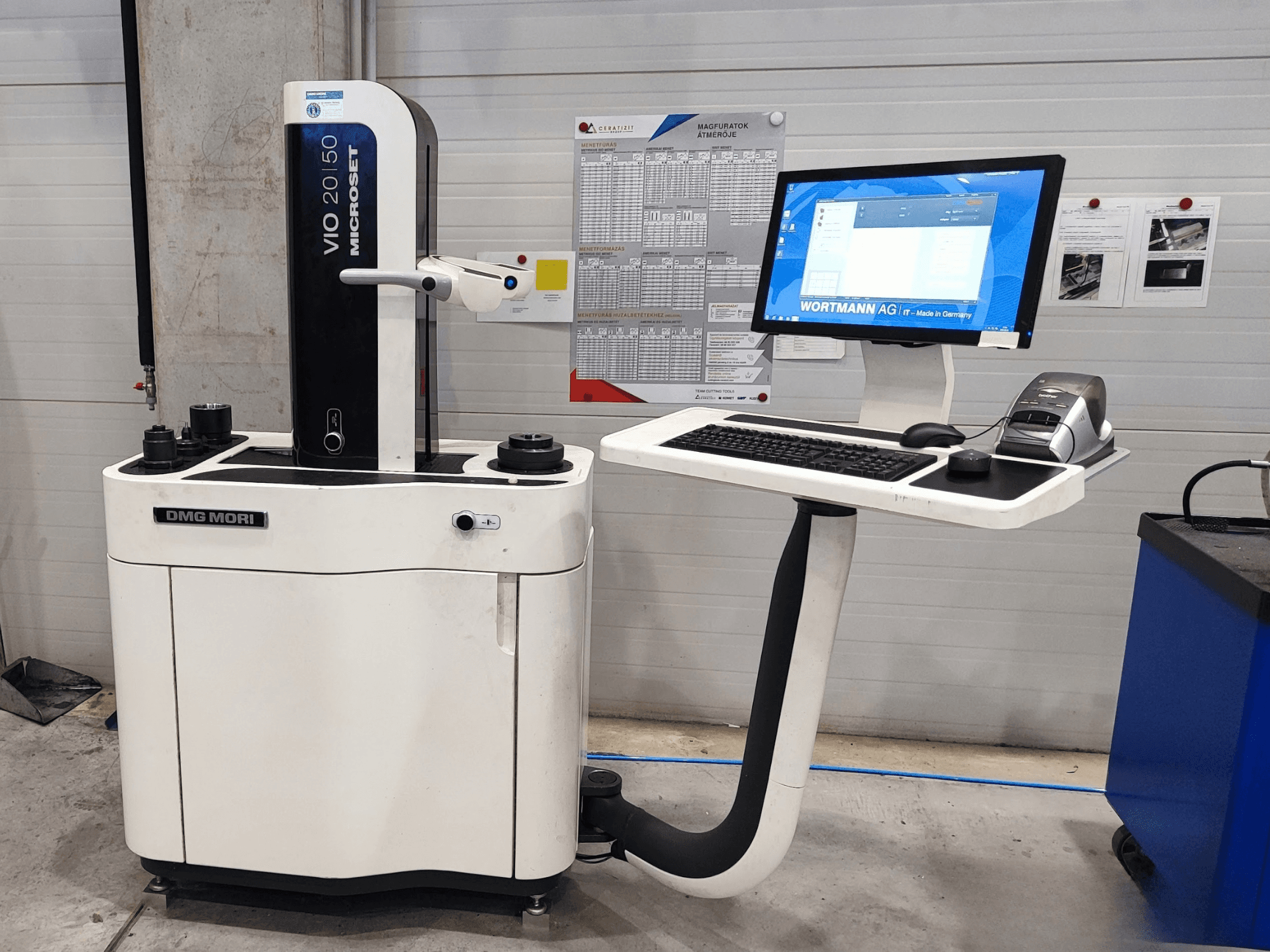Máquina de medición óptica DMG MORI VIO Basic vista de frente, equipada con una pantalla táctil, un teclado y sensores de medición.
