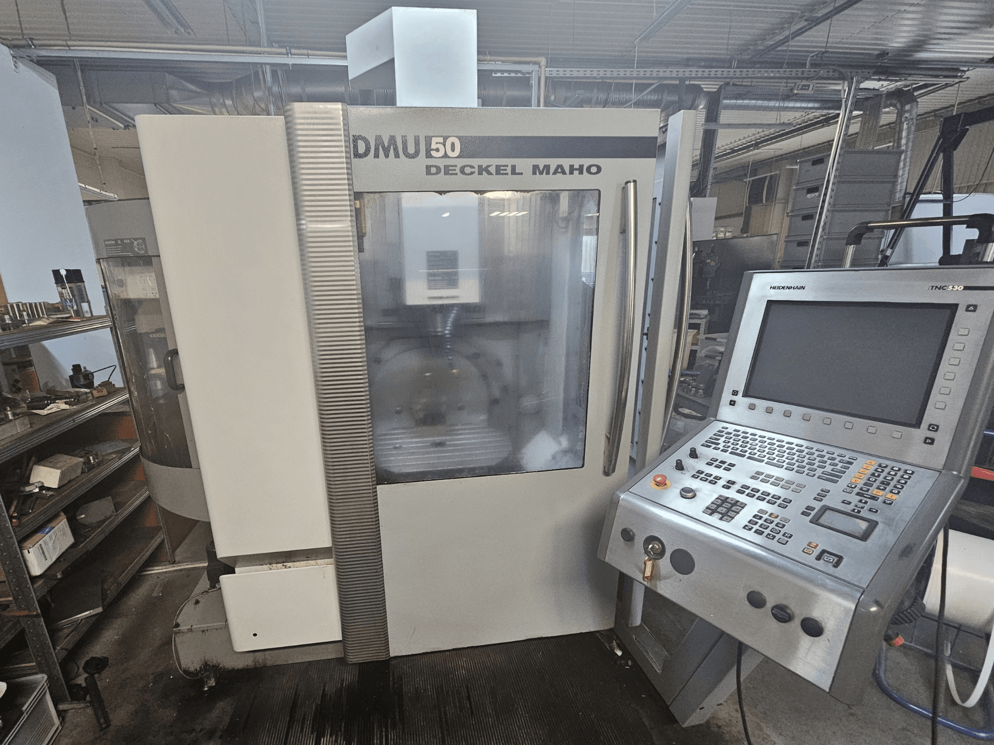 Máquina CNC DMU 50 Deckel Maho, vista frontal con panel de control y teclas de funcionamiento visibles, en un entorno de taller.