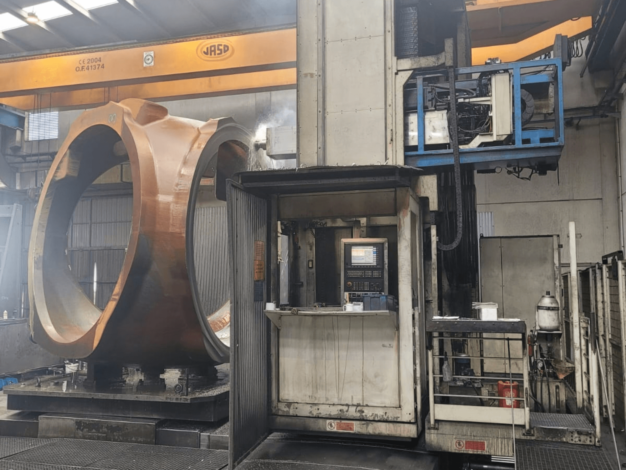Centro de fresado y torneado PAMA Speedram 1000, vista lateral, en la que se aprecia una pieza de trabajo de gran tamaño y el panel de control en un entorno industrial.