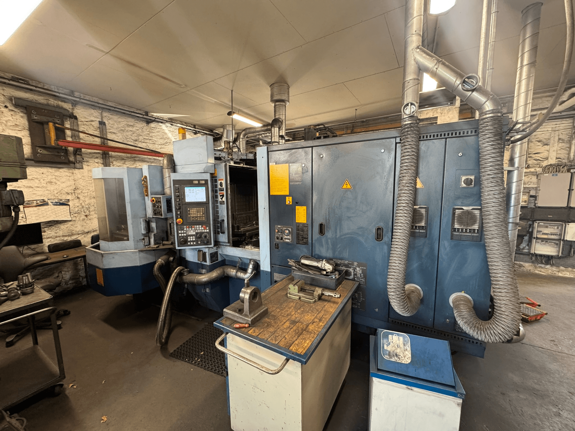 Centro de mecanizado horizontal Matsuura H.PLUS-300 en un taller, vista frontal, en la que se aprecian el panel de control y la mesa de trabajo.