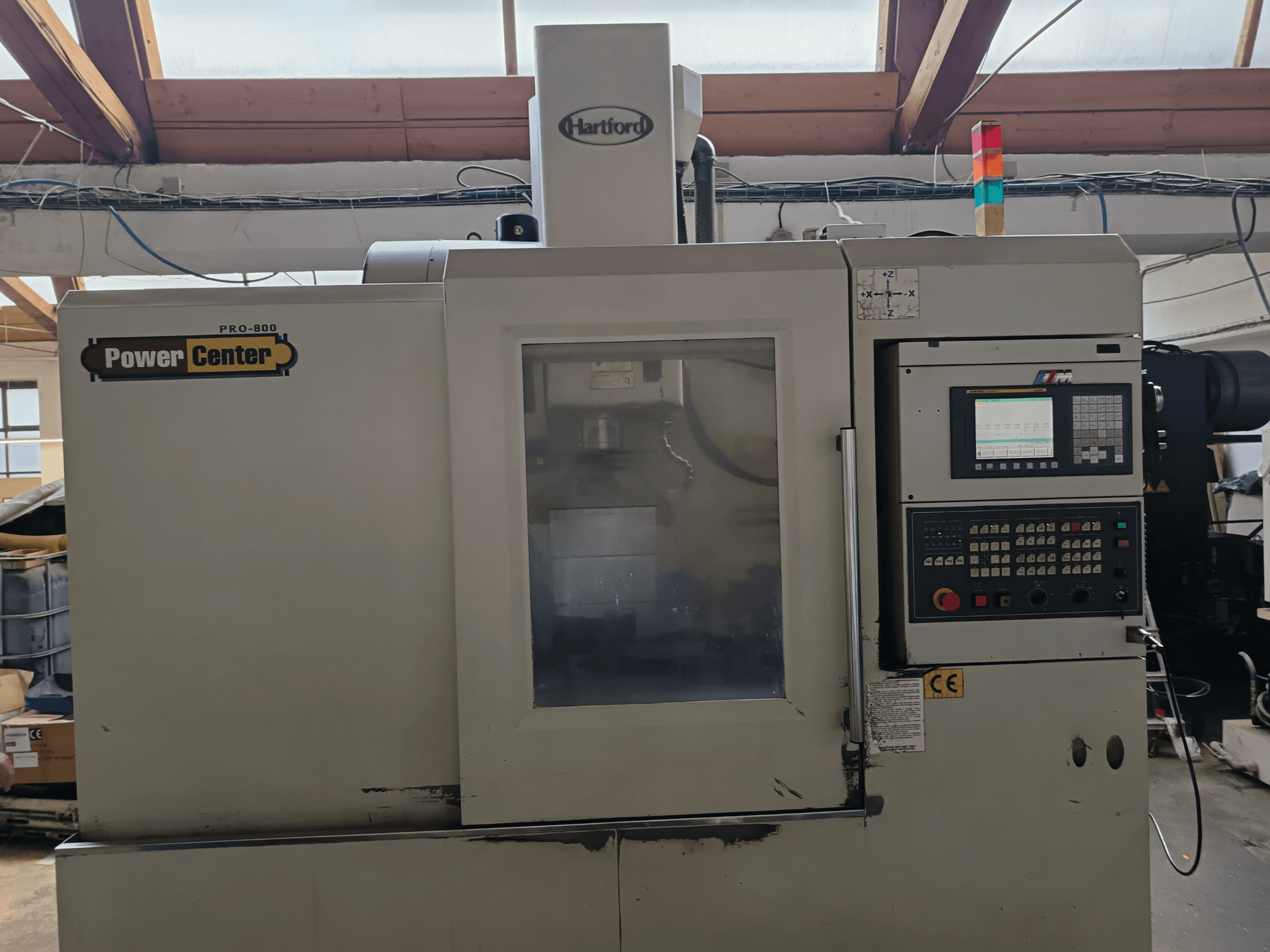 Centro de mecanizado vertical HARTFORD PRO-800A, vista frontal, en la que se aprecian el panel de control y el panel de cristal que permite ver el interior.