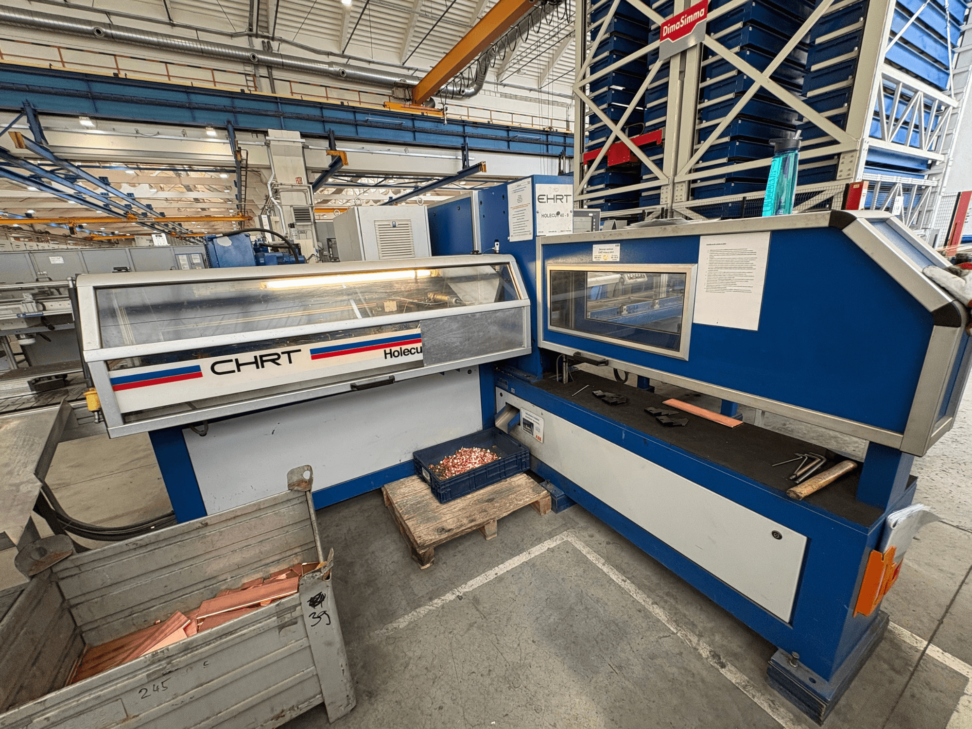 Punzonadora CNC EHRT Holecut 40-9, vista frontal, con panel de control, contenedor de metal y chapas de cobre cerca.