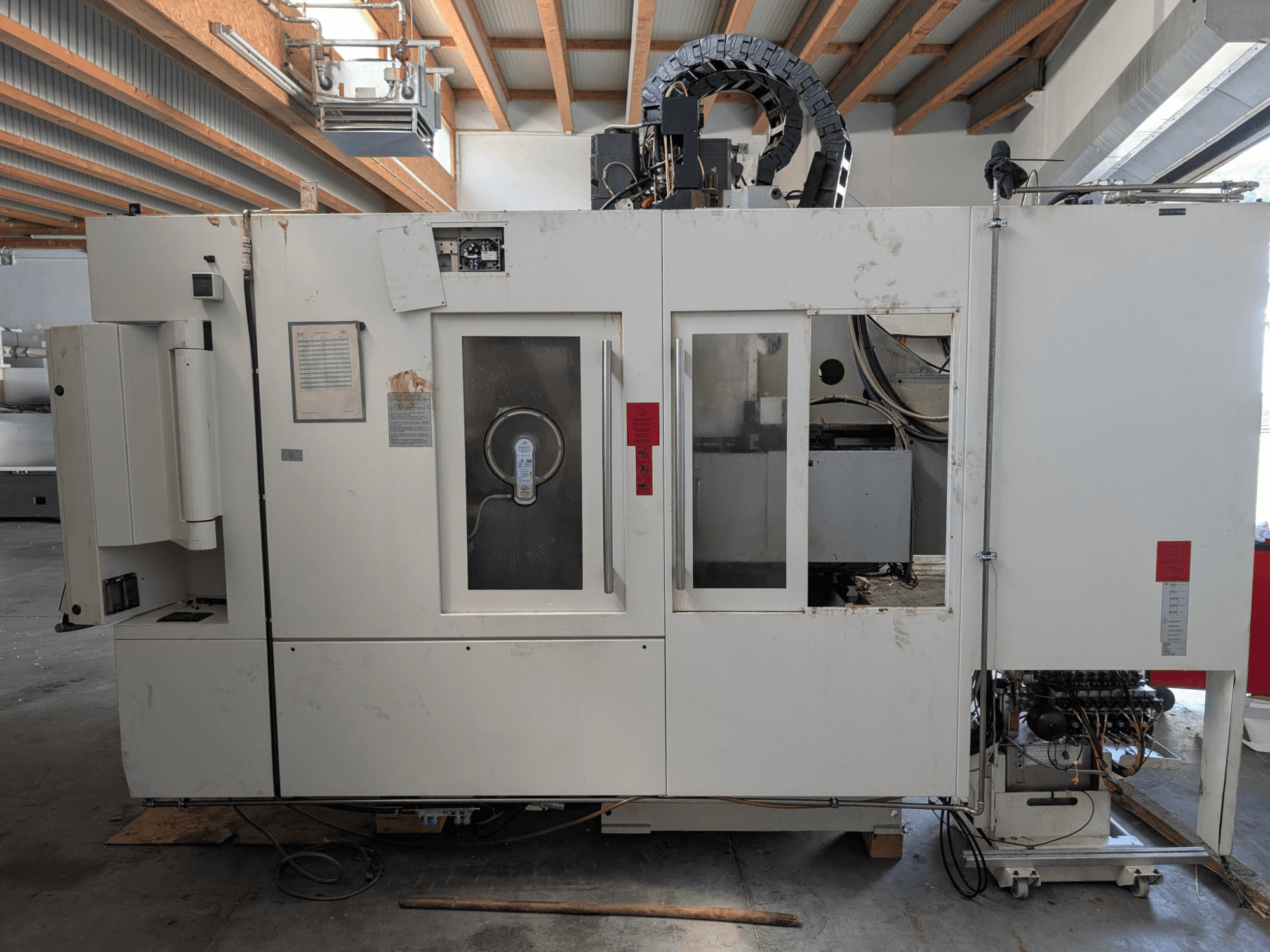 Centro de mecanizado vertical STAMA MC 326, vista lateral mostrando el panel de control, la zona del husillo y varias etiquetas en la máquina.