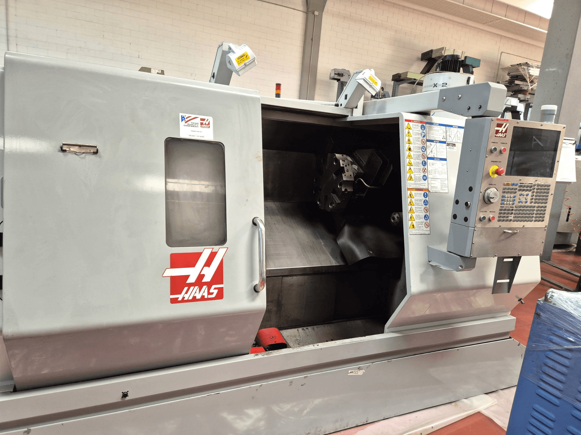 Torno horizontal Haas SL 30TBHE, vista frontal en la que se aprecian los mandos y el compartimento abierto para las operaciones de mecanizado.
