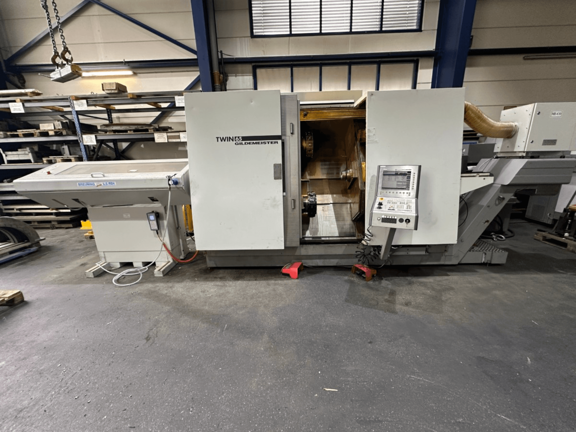 Torno horizontal Gildemeister TWIN 65, vista frontal; dispone de panel de control e interior visible para el mecanizado de piezas.