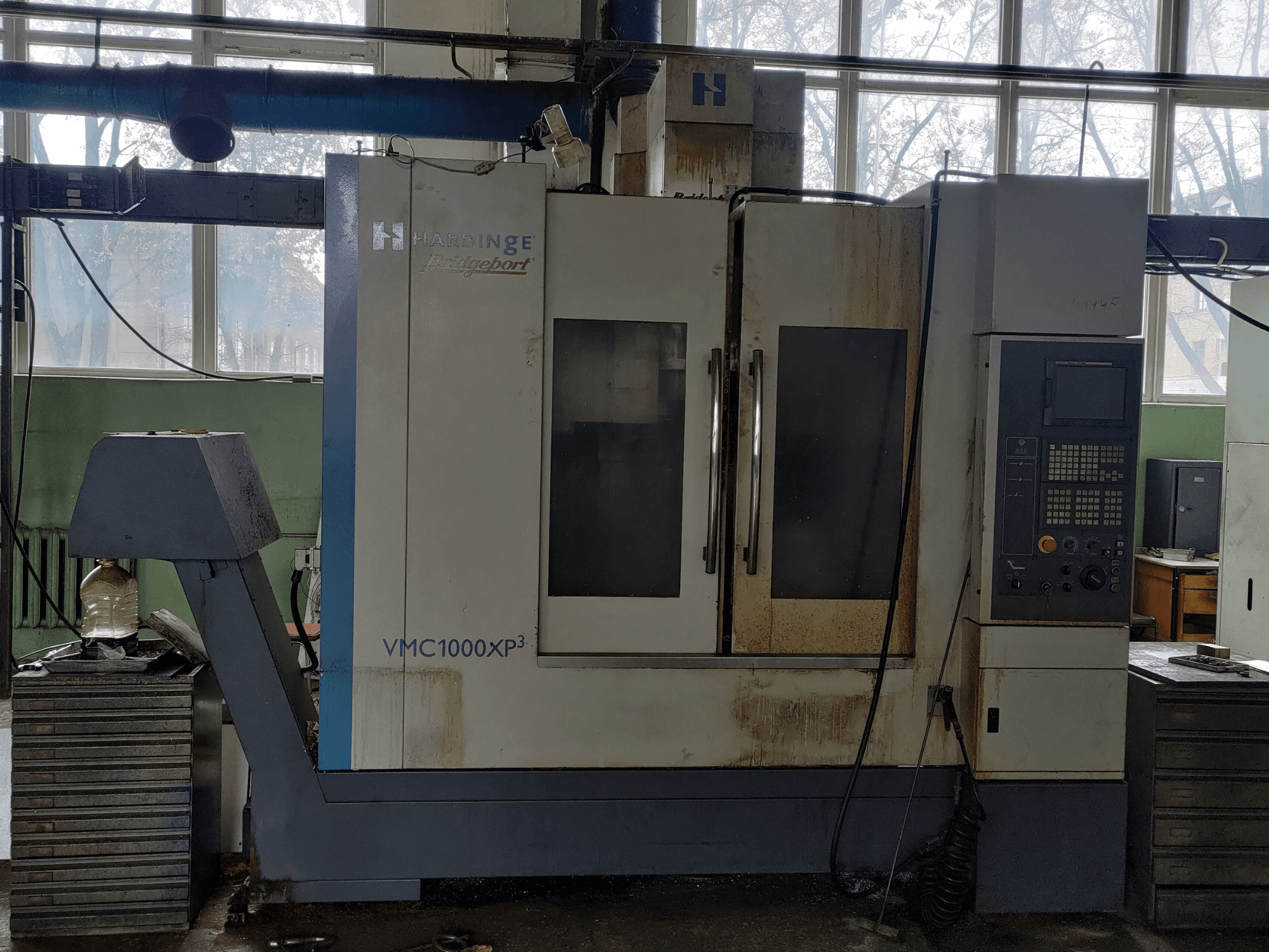 Centro de mecanizado vertical Bridgeport VMC1000 XP3 visto de frente, en el que se aprecian el panel de control y un ligero desgaste.