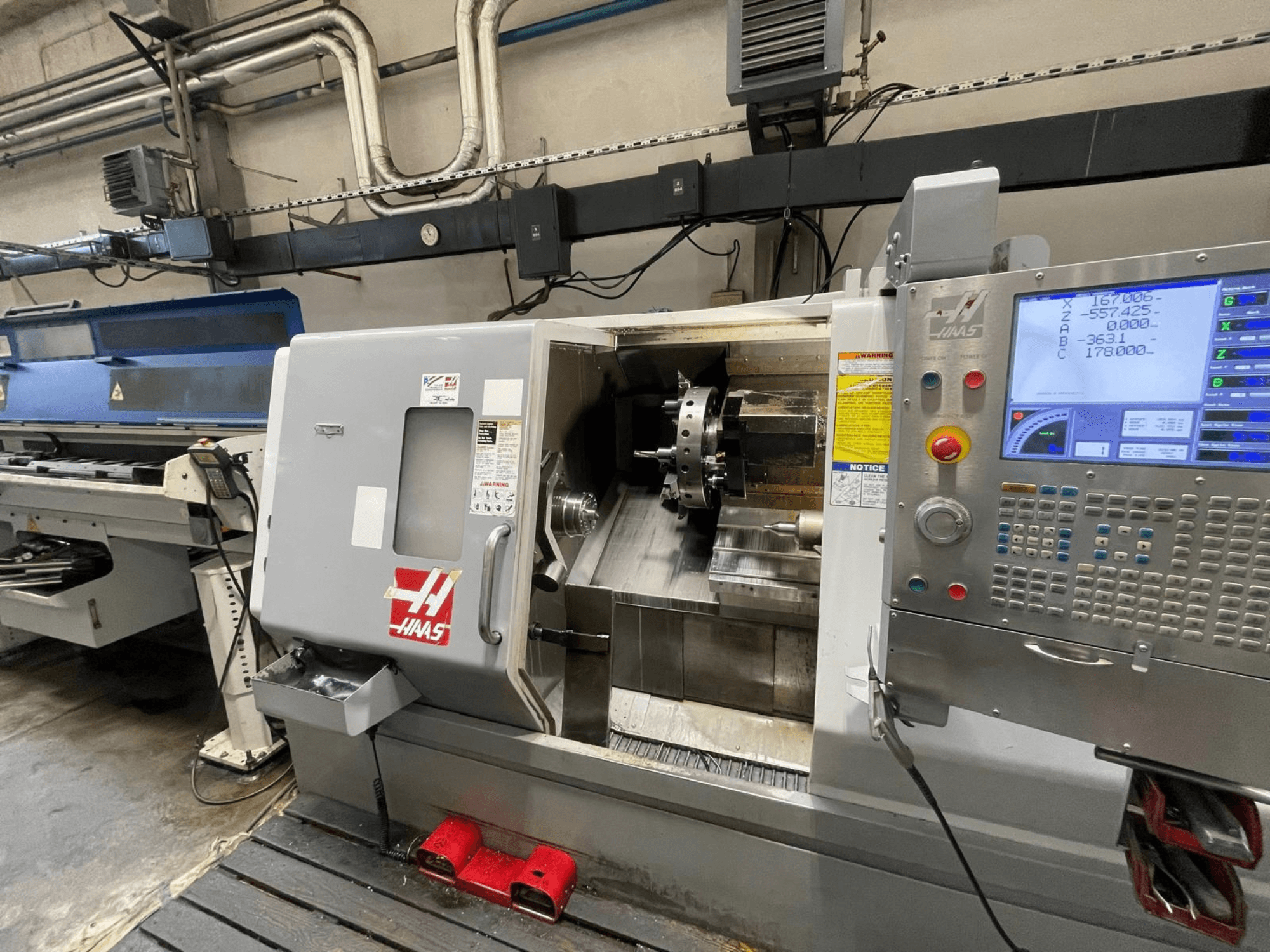 El torno horizontal Haas SL-30THE en un taller, con un panel de control digital y una zona de trabajo a la vista.