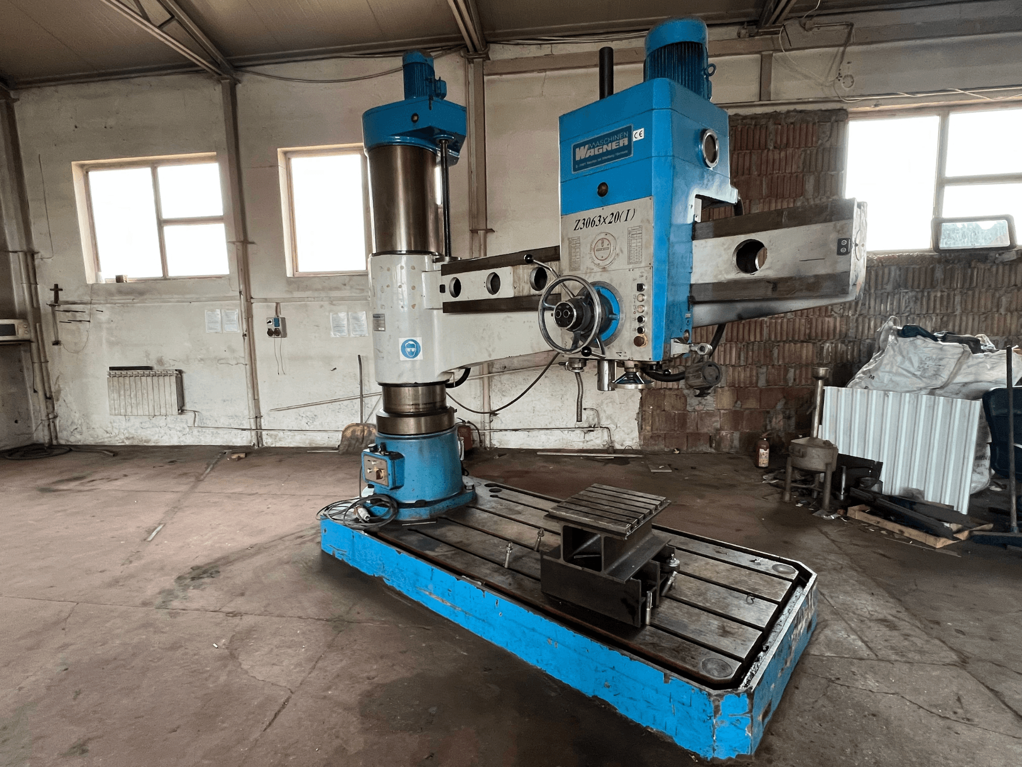 Taladro Wagner Z3063x210 en un taller, vista frontal; presenta un diseño azul y plateado con base metálica y mesa de trabajo.