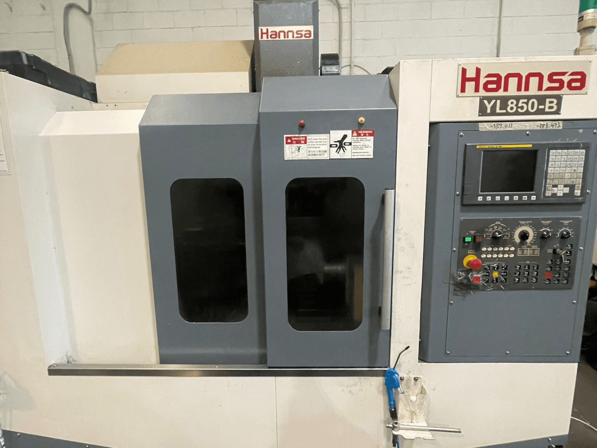 Centro de mecanizado vertical HANNSA YL850-B, vista frontal, con panel de control, botones de operación y ventanas de observación dobles.