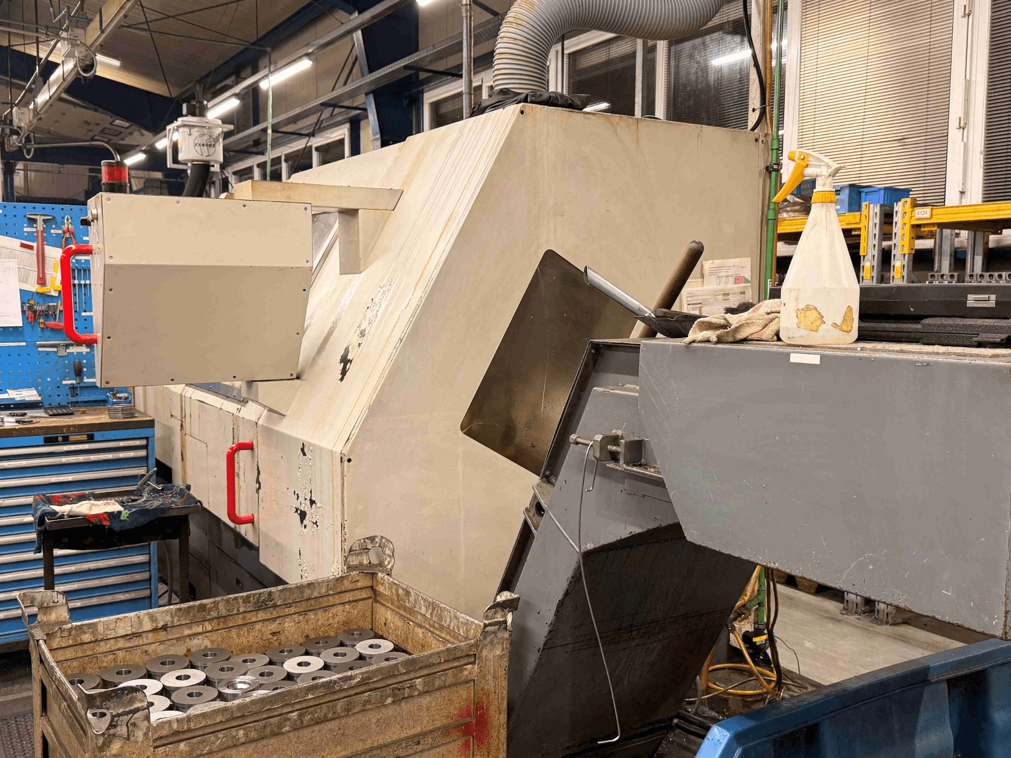 Torno horizontal CNC ZPS S-60 en el taller, en una vista lateral en la que se aprecian las piezas de trabajo y los mandos.