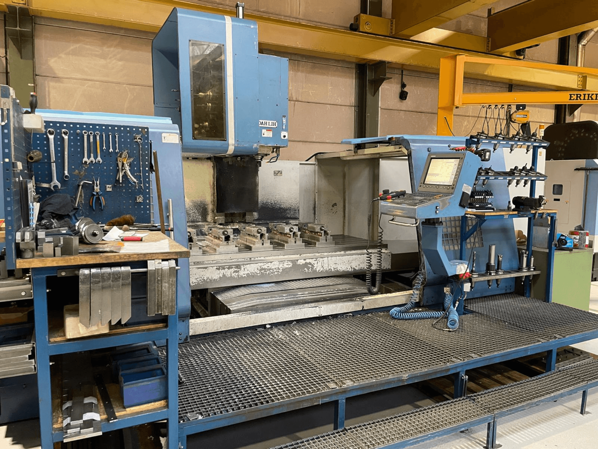 Vista frontal del centro de mecanizado vertical DAH LIH MCV2600, que muestra el panel de control, la mesa de trabajo y el área de almacenamiento de herramientas.