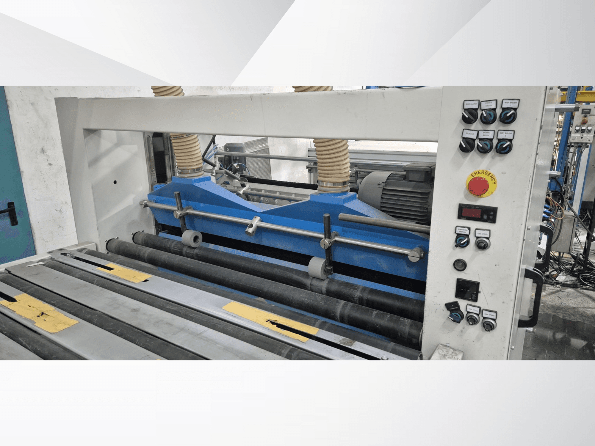 Máquina enrolladora industrial con componentes azules, vista frontal, con panel de control y botón de parada de emergencia.