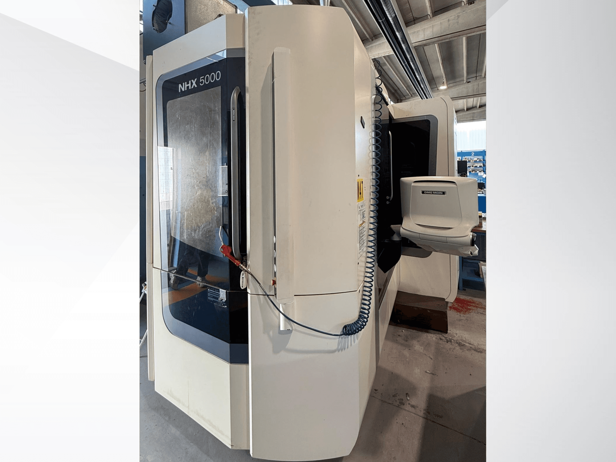 Torno horizontal DMG MORI NHX 5000, vista frontal, en la que se aprecian el panel de control y el portahusillo.