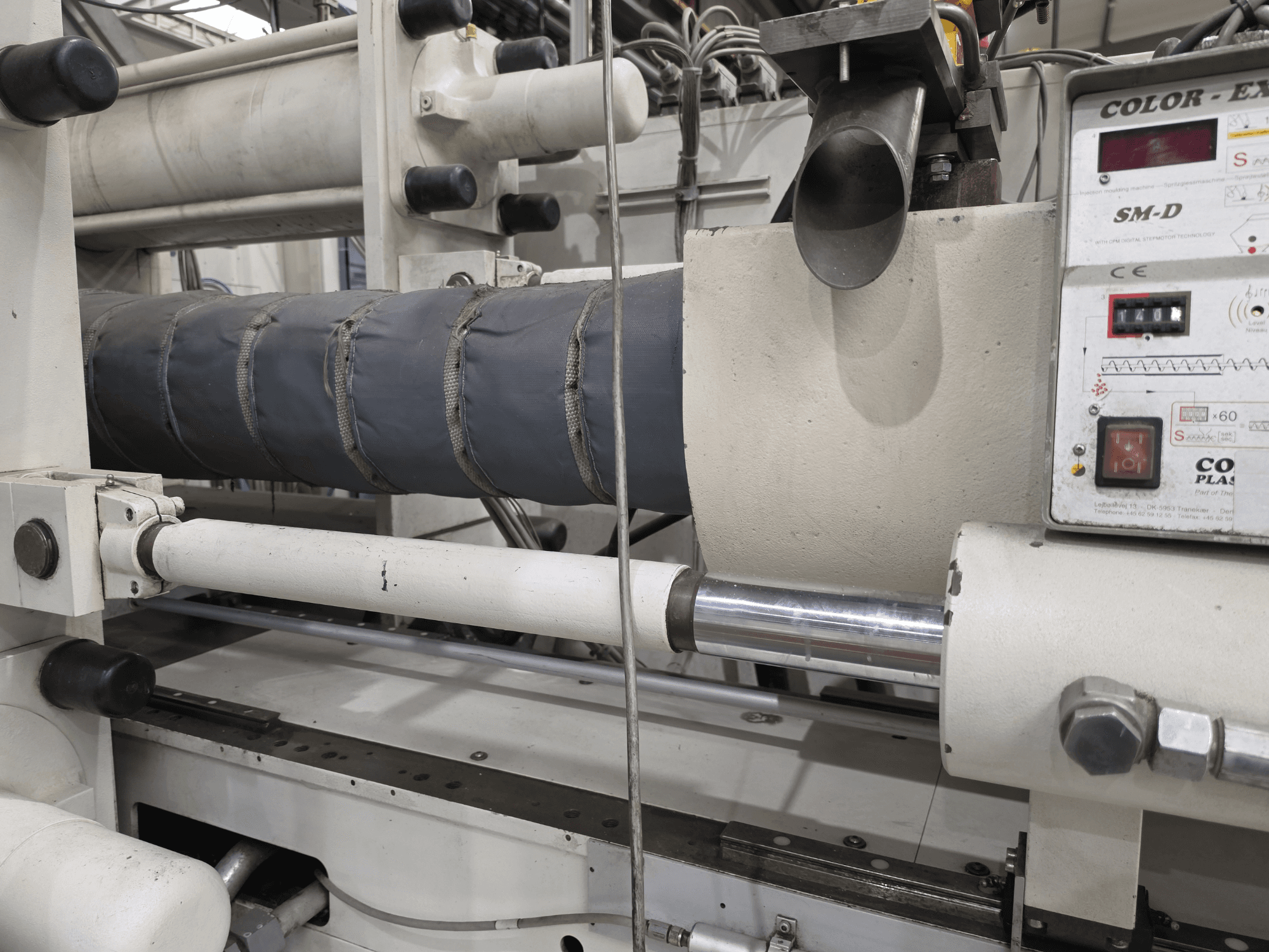 Máquina de moldeo por inyección hidráulica Krauss Maffei 350-3000 CX, vista lateral que muestra el panel de control de temperatura y los elementos calefactores.
