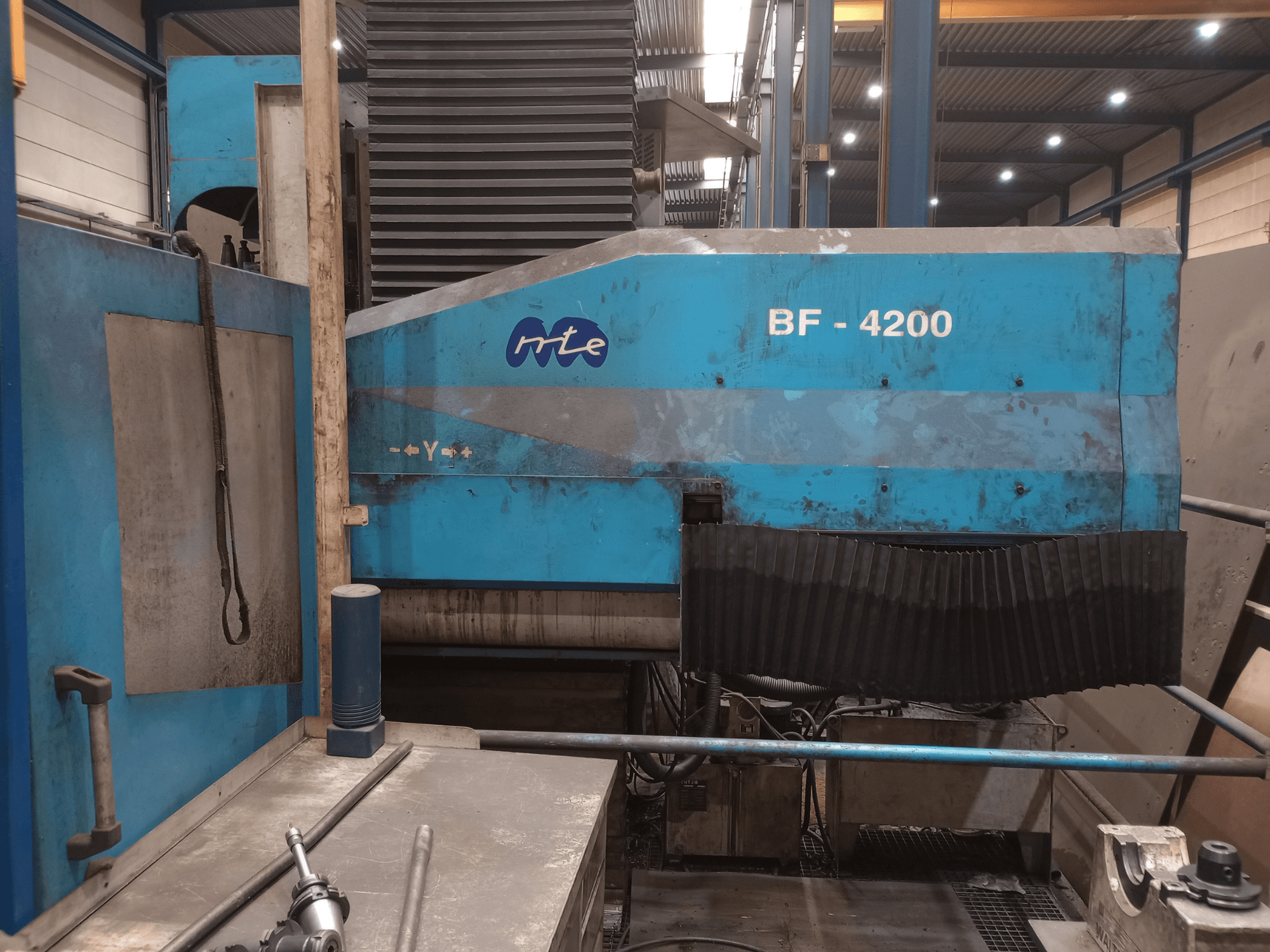 Fresadora de bancada MTE BF 4200, vista lateral, en la que se aprecia el exterior azul y los componentes detallados de la máquina en un entorno de taller.