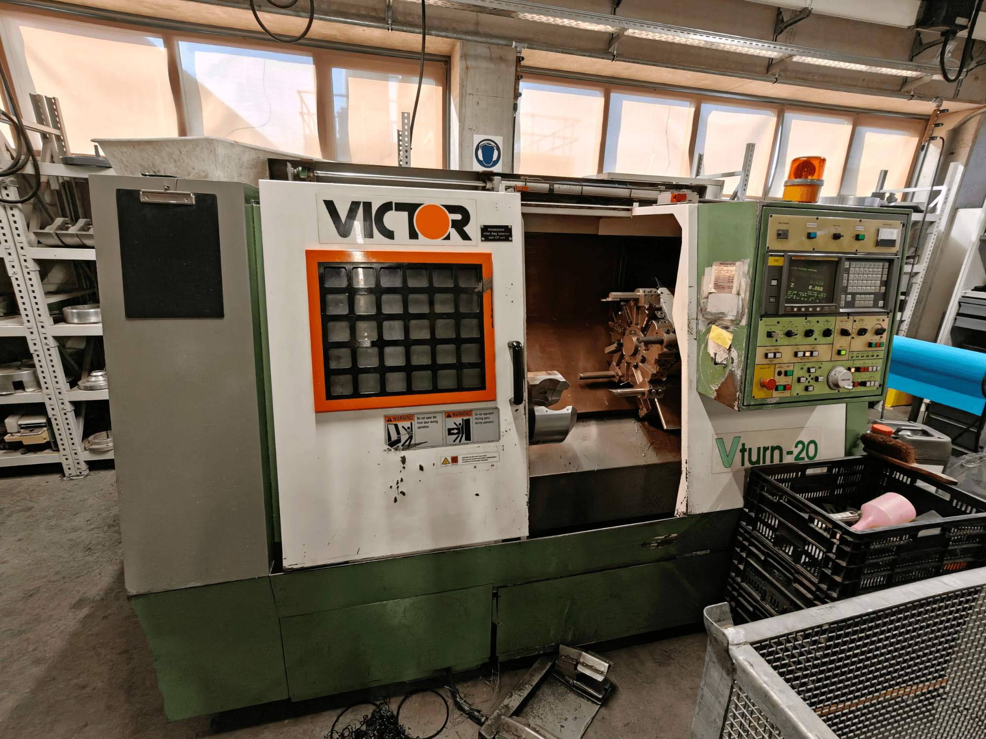 Máquina de torneado horizontal Victor Vturn-20, vista lateral, mostrando el panel de control, el husillo y el espacio de trabajo para el mecanizado.