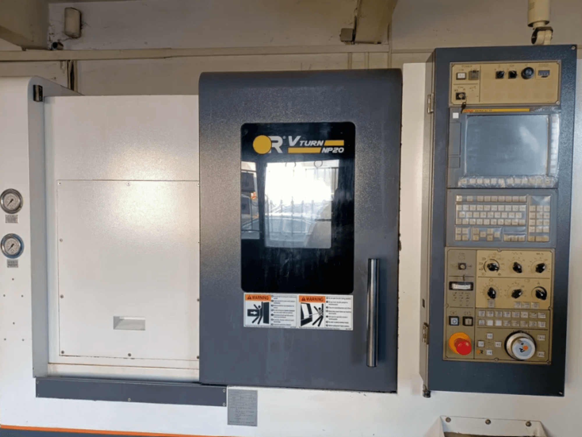 Vista frontal de la máquina CNC OR VTURN NP20, con panel de control con botones, pantalla e indicadores en el lateral.