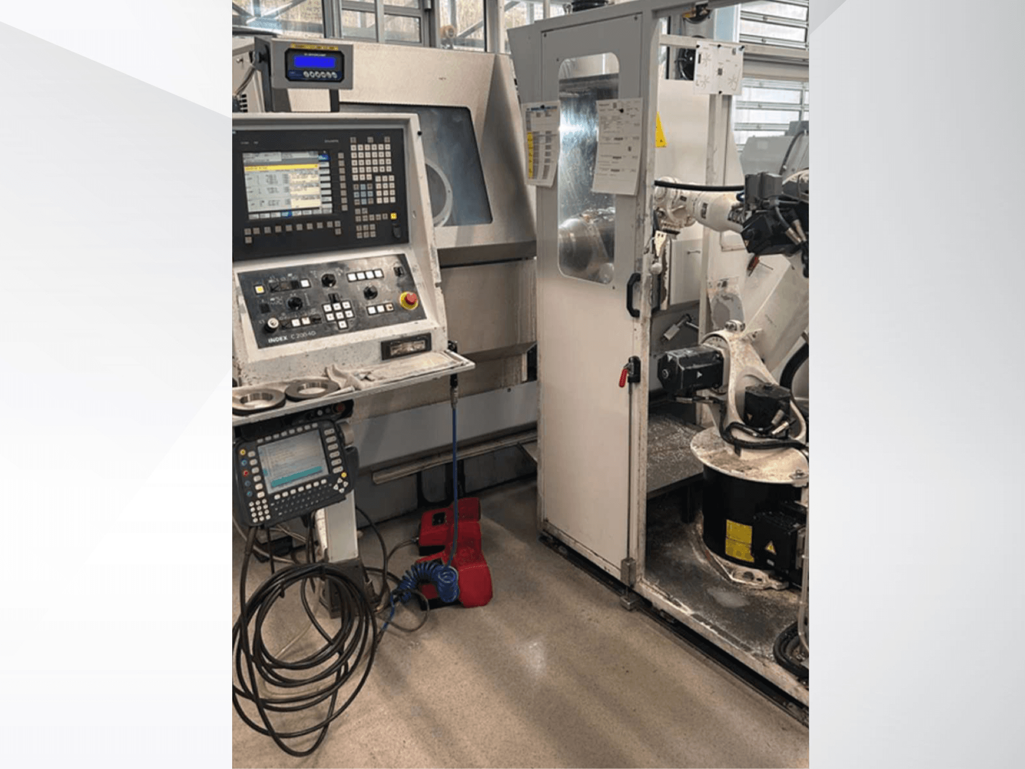 Vista frontal del centro de torneado y fresado Index G 200 RATIO LINE, con panel de control, brazo robotizado y espacio de trabajo operativo.