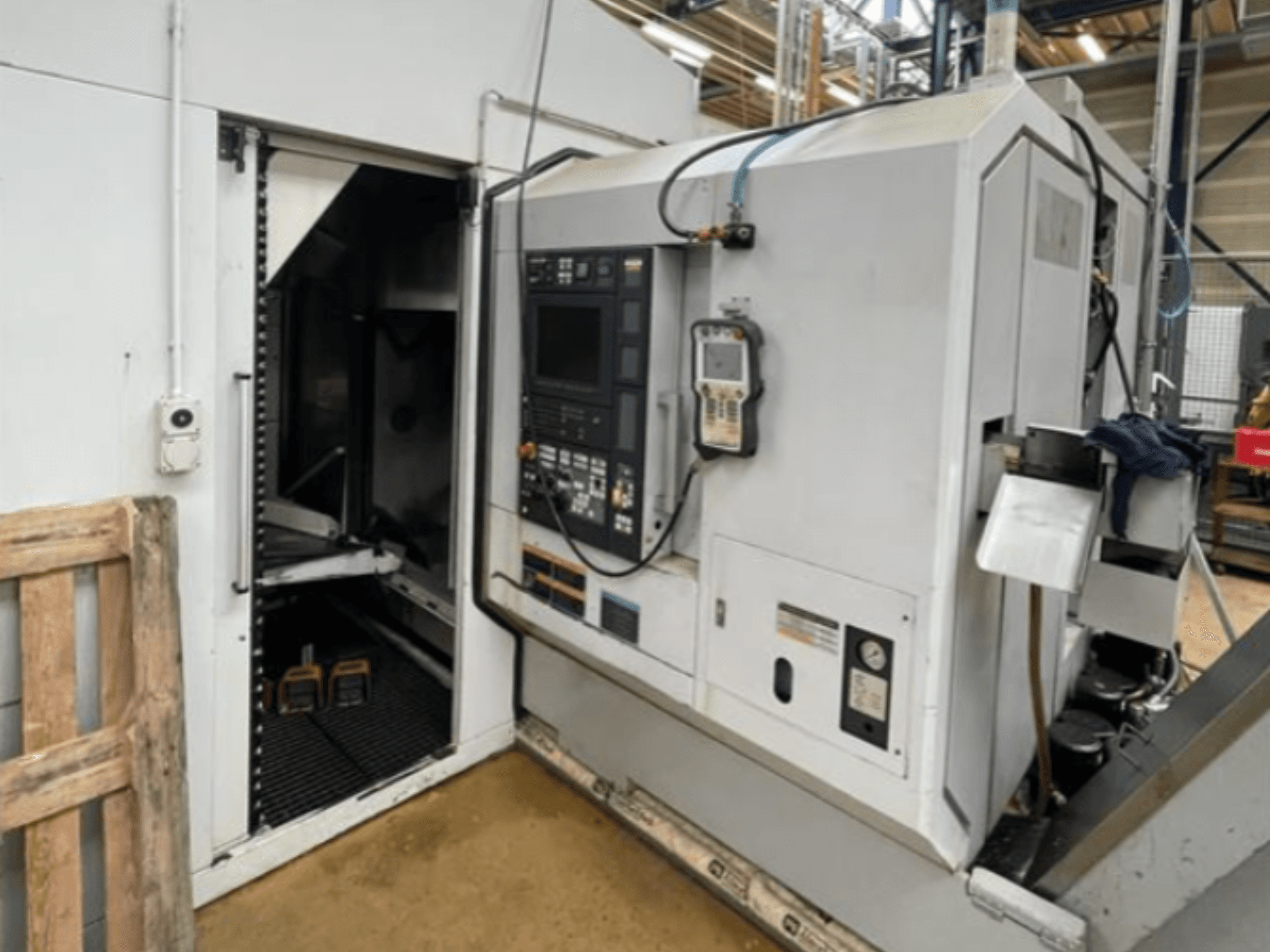 DMG Mori Seiki NZ2000T3Y2 máquina de torneado horizontal, vista lateral mostrando el panel de control y el interior de la máquina.