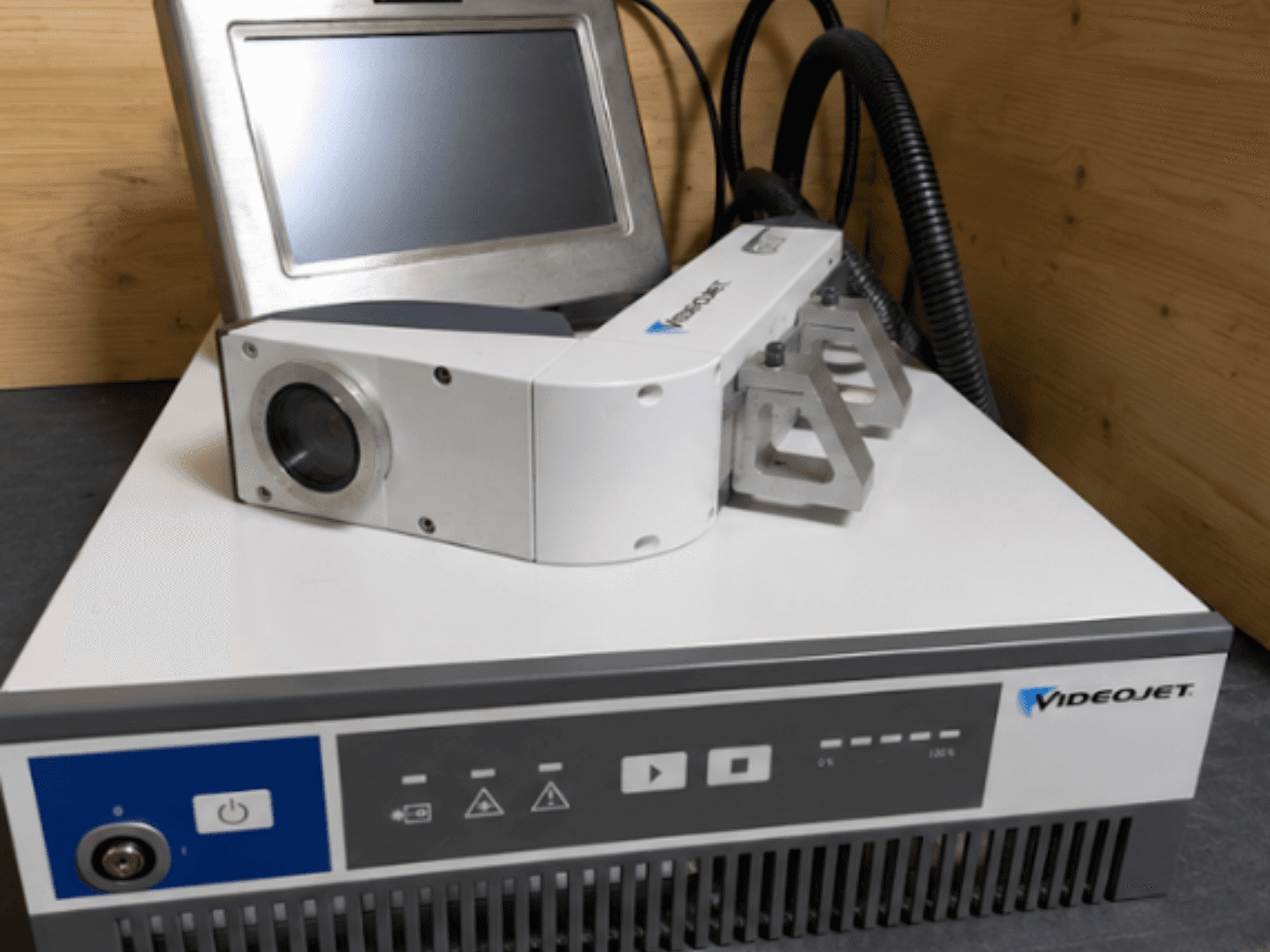 Máquina de grabado láser Videojet 7230, vista frontal, mostrando el panel de control y el cabezal láser con lente y accesorio.