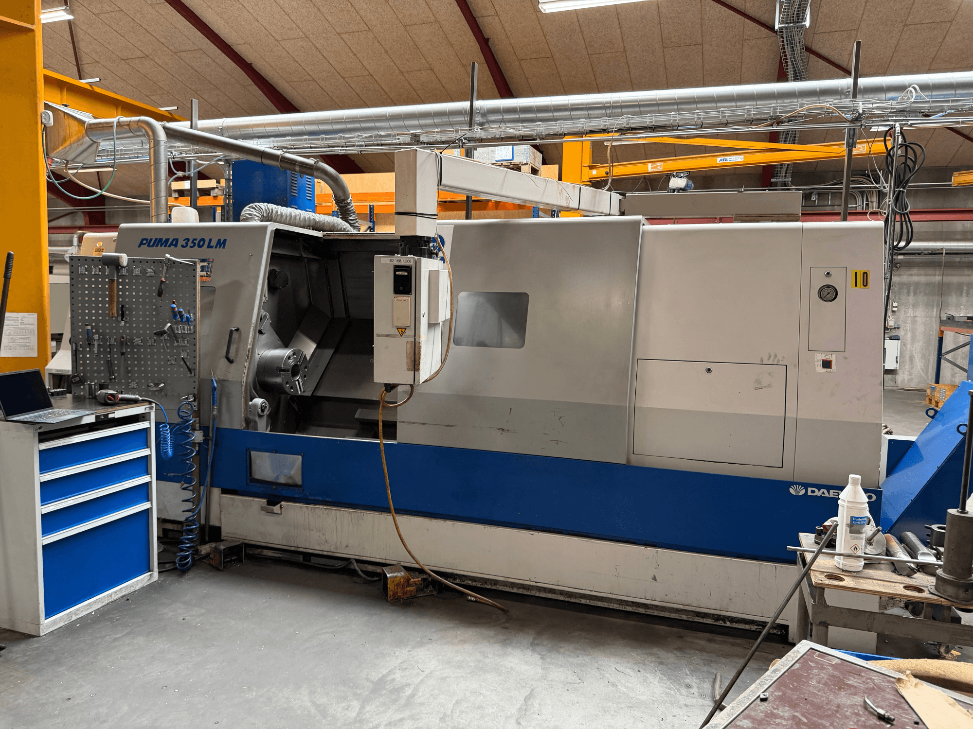 Torno horizontal DAEWOO Puma 350 LMA, vista lateral, en la que se aprecian el panel de control y el espacio de trabajo con las herramientas.