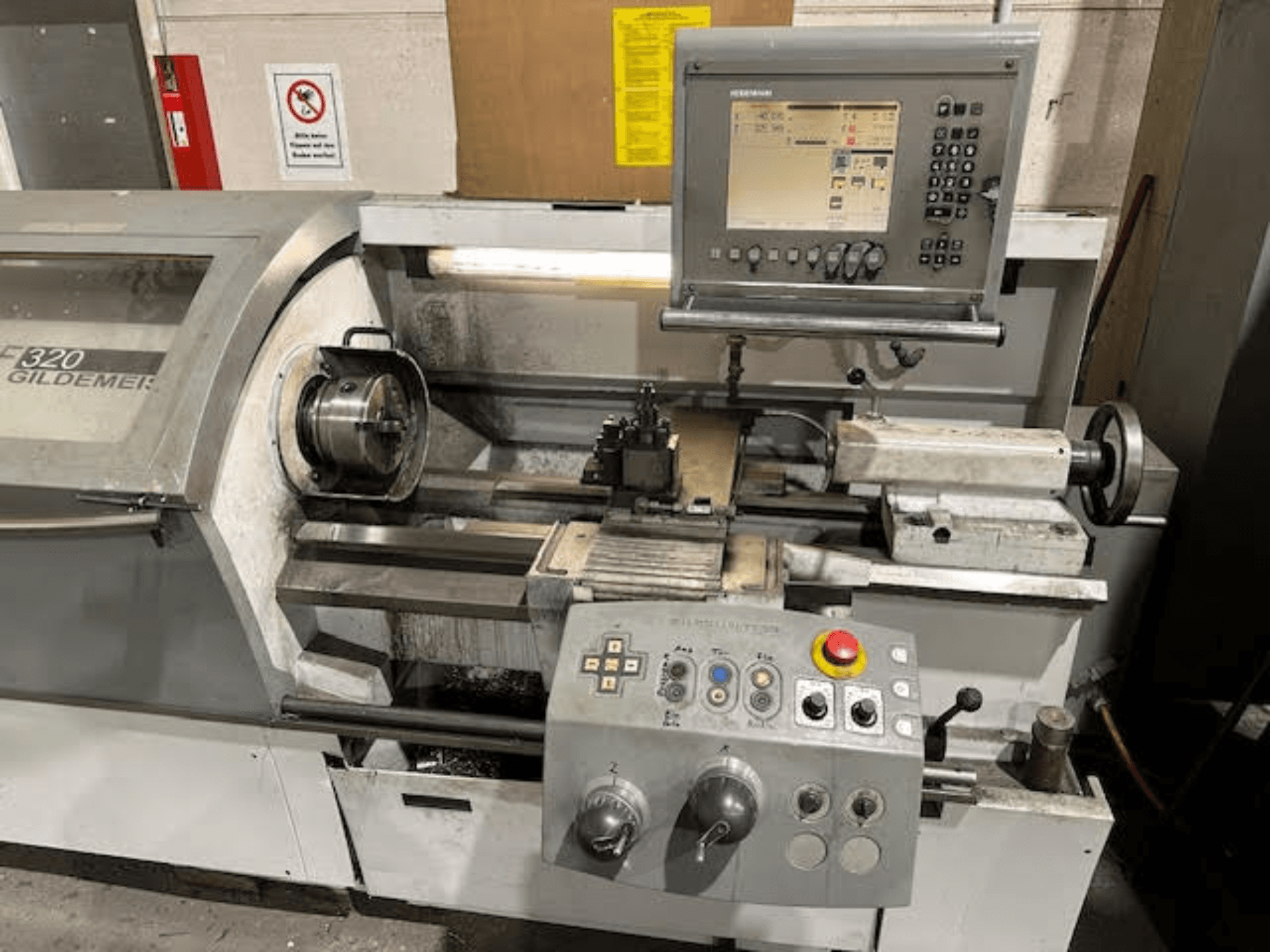 Torno horizontal HERMLE NEF 320, vista frontal en la que se aprecian el panel de control, la zona de herramientas y la pieza de metal colocada en la máquina.