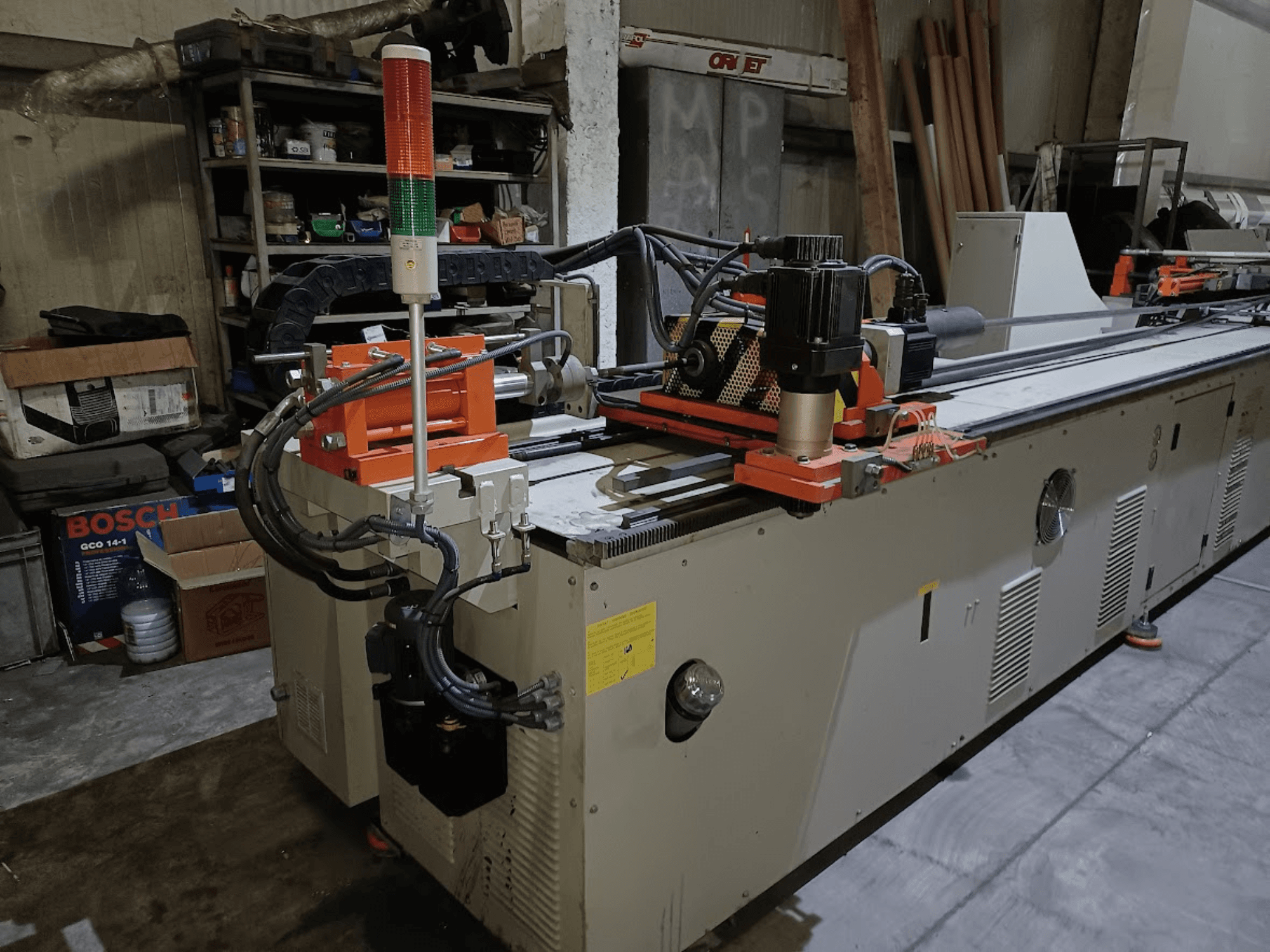 Máquina plegadora CANSA CNC 51 R1, vista lateral, en la que se aprecian el panel de control, el motor y las luces indicadoras en un entorno de taller.