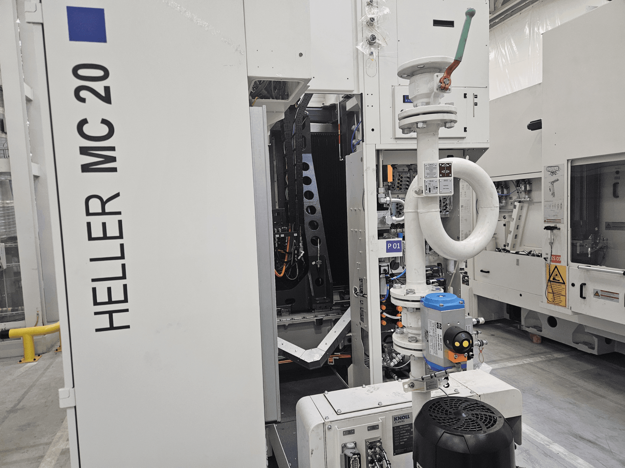 Máquina Heller MC 20 en un entorno de fábrica, mostrando el panel de control y los componentes mecánicos desde una vista lateral.