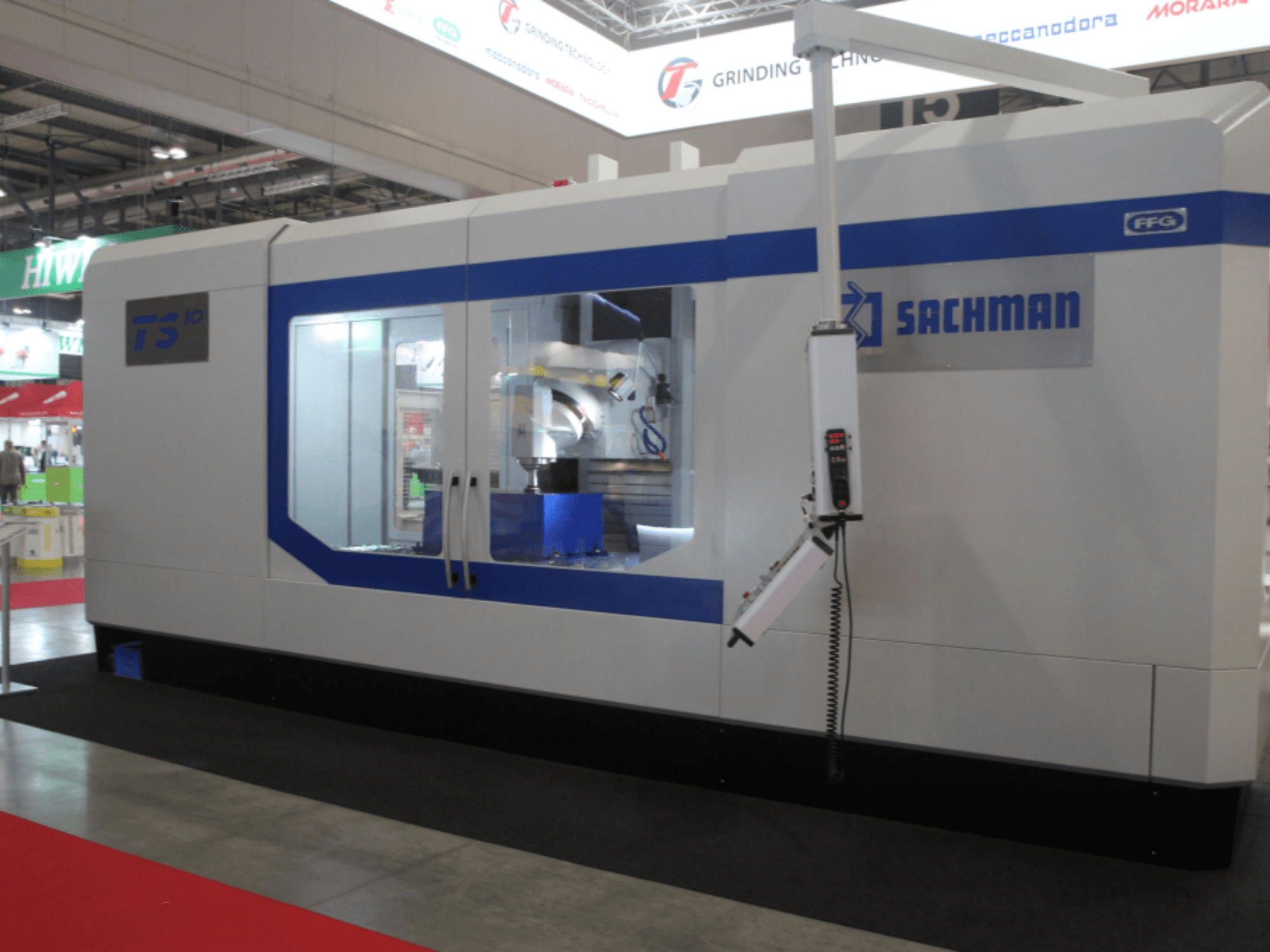 Fresadora de bancada SACHMAN TS10, vista frontal, mostrando los controles, el espacio de trabajo y el elegante diseño en una feria comercial.