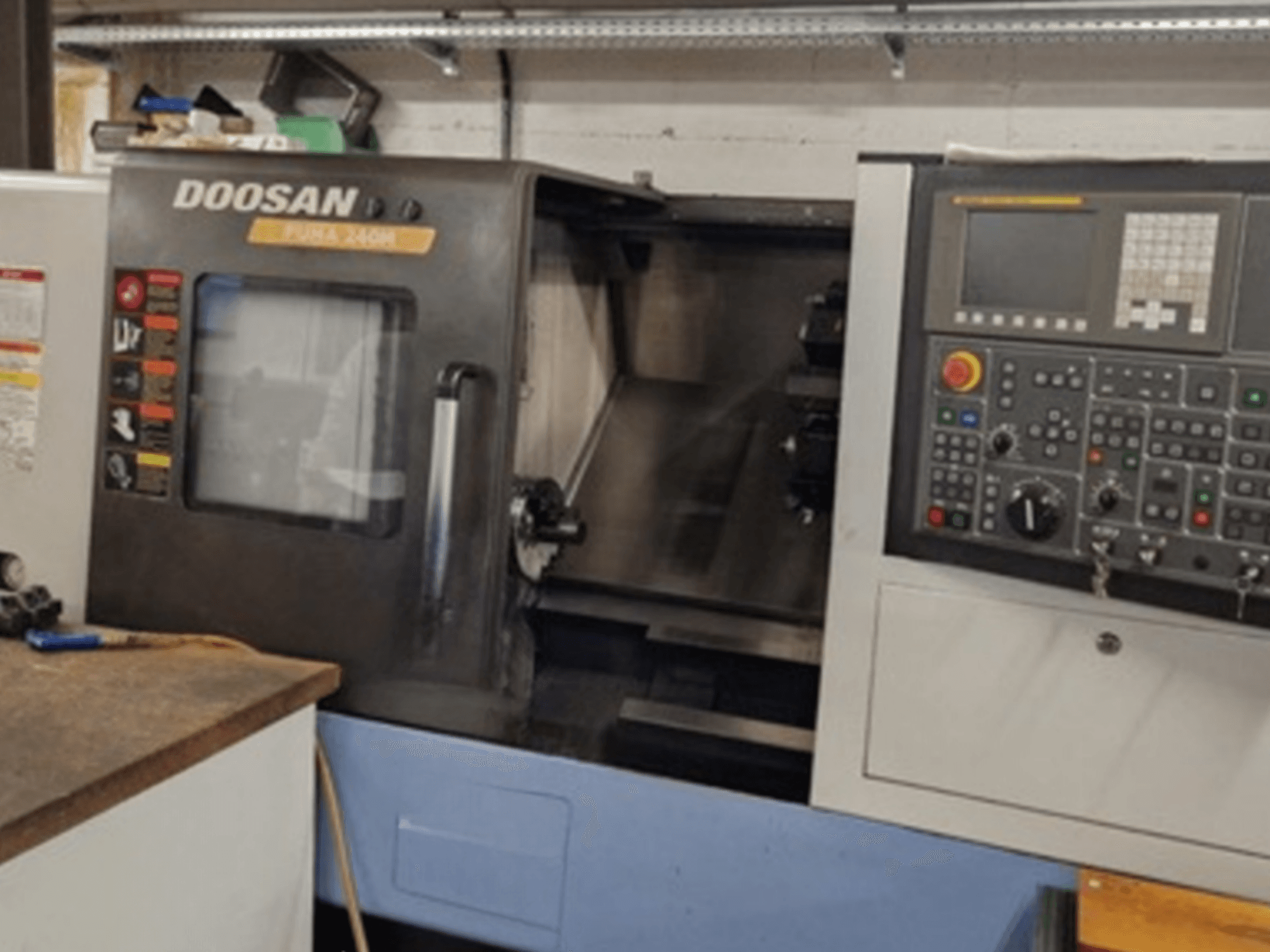 Vista frontal del torno horizontal DOOSAN Puma 240MB mostrando el panel de control y las funciones operativas.