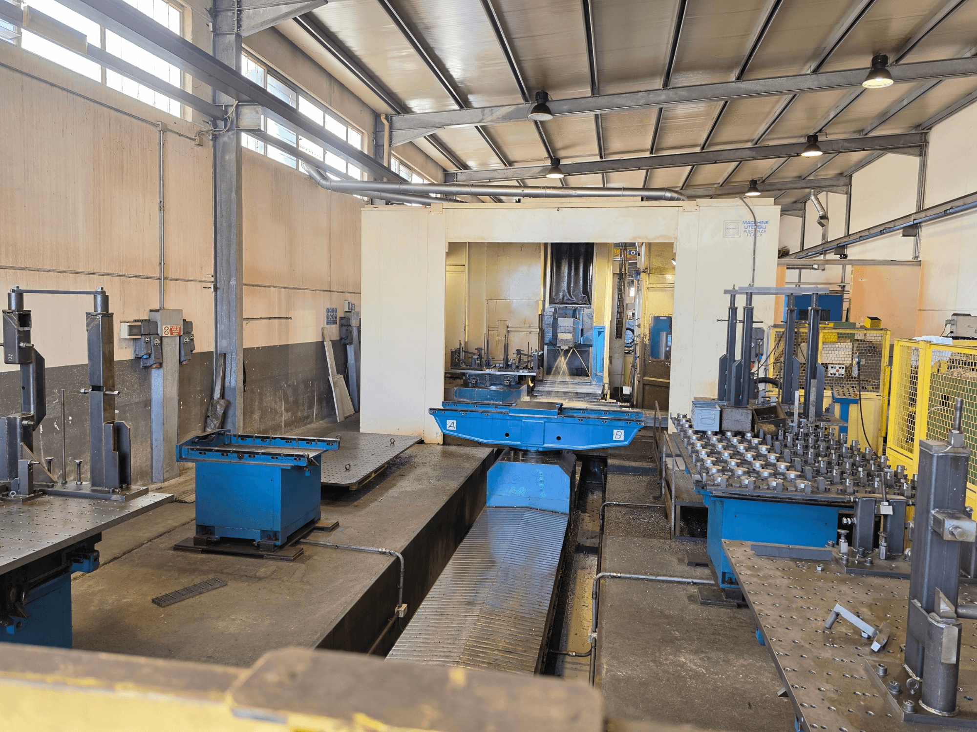 Centro de mecanizado horizontal Mandelli RS1500U en un entorno industrial, en el que se pueden apreciar la maquinaria, las herramientas y las superficies de trabajo.