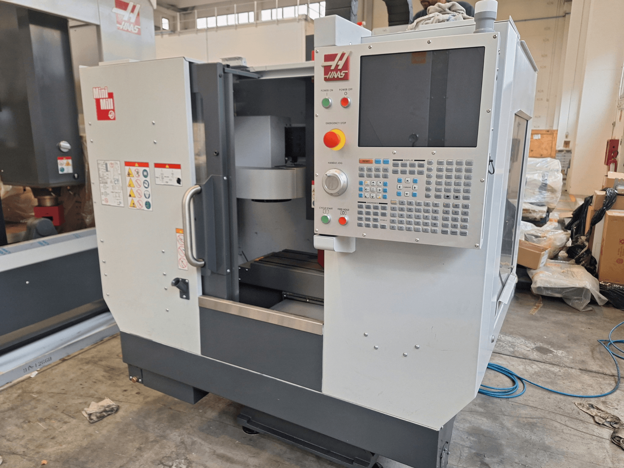 Centro de mecanizado vertical HAAS Mini Mill visto desde delante, con un panel de control provisto de botones y una pantalla.